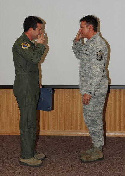 Lt. Col. Marc London, 7th Bomb Wing, presents Master Sgt. Douglas Metcalf, 7 BW, with the February 7 BW superior performer award, Feb. 9,  2012, at Dyess Air Force Base, Texas. Every month each group selects one person or team who has shown superior performance to be recognized in front of wing leadership. (U.S. Air Force photo by Airman 1st Class Peter Thompson/Released) 