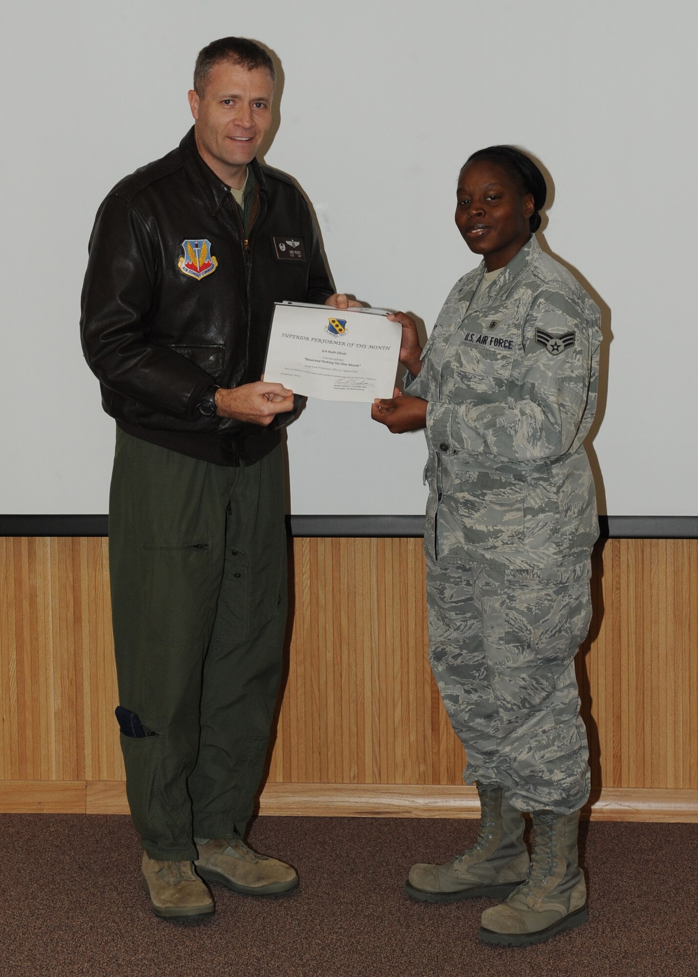Lt. Col. David Rogers, 7th Aerospace Medicine Squadron  commander, presents  Senior Airman Ruth Elliot, 7 AMDS, with the February 7th Medical Group superior performer award, Feb. 9,  2012, at Dyess Air Force Base, Texas. Every month each group selects one person or team who has shown superior performance to be recognized in front of wing leadership. (U.S. Air Force photo by Airman 1st Class Peter Thompson/Released) 