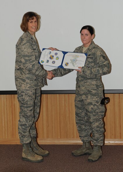 Col. Kristina O’Brien, 7th Mission Support Group commander, presents Staff Sgt. Kelly Stamelos, 7 MSG, with the February 7 MSG superior performer award, Feb. 9,  2012, at Dyess Air Force Base, Texas. Every month each group selects one person or team who has shown superior performance to be recognized in front of wing leadership. (U.S. Air Force photo by Airman 1st Class Peter Thompson/Released)