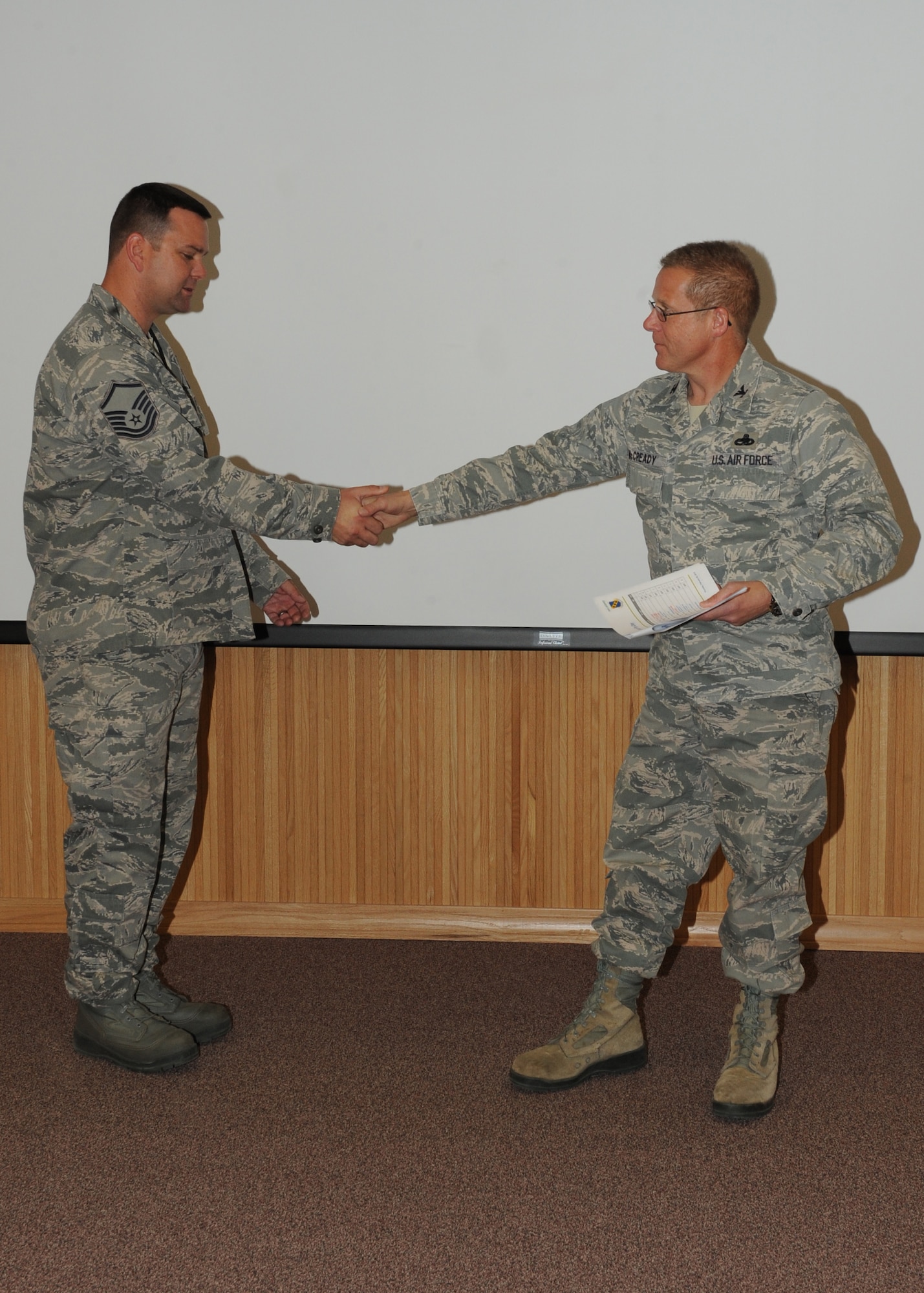 Col. Todd McCready, 7th Maintenance Group  commander, presents Master Sgt. Gregory Kerr, 7 MXG, with the February 7 MXG superior performer award, Feb. 9,  2012, at Dyess Air Force Base, Texas. Every month each group selects one person or team who has shown superior performance to be recognized in front of wing leadership. (U.S. Air Force photo by Airman 1st Class Peter Thompson/Released) 