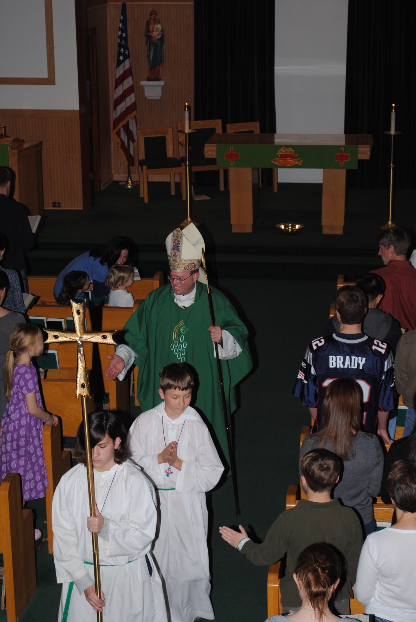 Altar servers Lizzy Dobronsky and Brian Callaway lead the Most Reverend Neal Buckon, Auxiliary Bishop for the Archdiocese for the Military Services down the isle after Catholic mass Sunday afternoon at the Base Chapel.  Over 100 members of the base Catholic community attended mass and a meal afterward during the bishop’s Super Bowl Sunday parish visit. (U.S. Air Force Photo/Sonic Johnson)