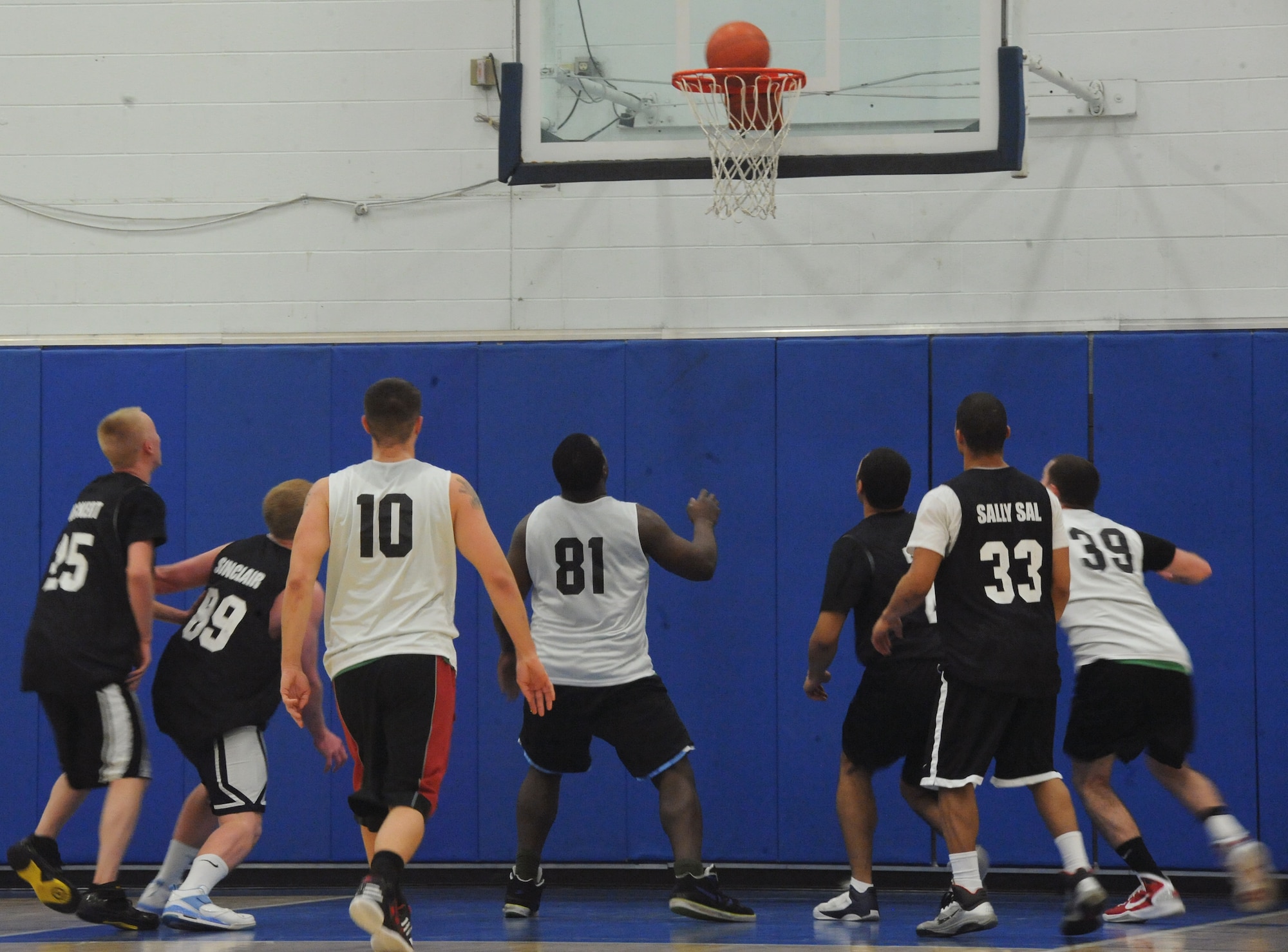 Players from the 319th Operations Support Squadron and 319th Security Forces Squadron basketball teams watch as the ball falls through the hoop for two points during the base intramural basketball championship game at the Fitness Center on Grand Forks Air Force Base, N.D., Feb. 08, 2012.  The Security Forces team won the game 49-43, capping off a 6-1 season.  (U.S. Air Force photo by Airman 1st Class Xavier Navarro)