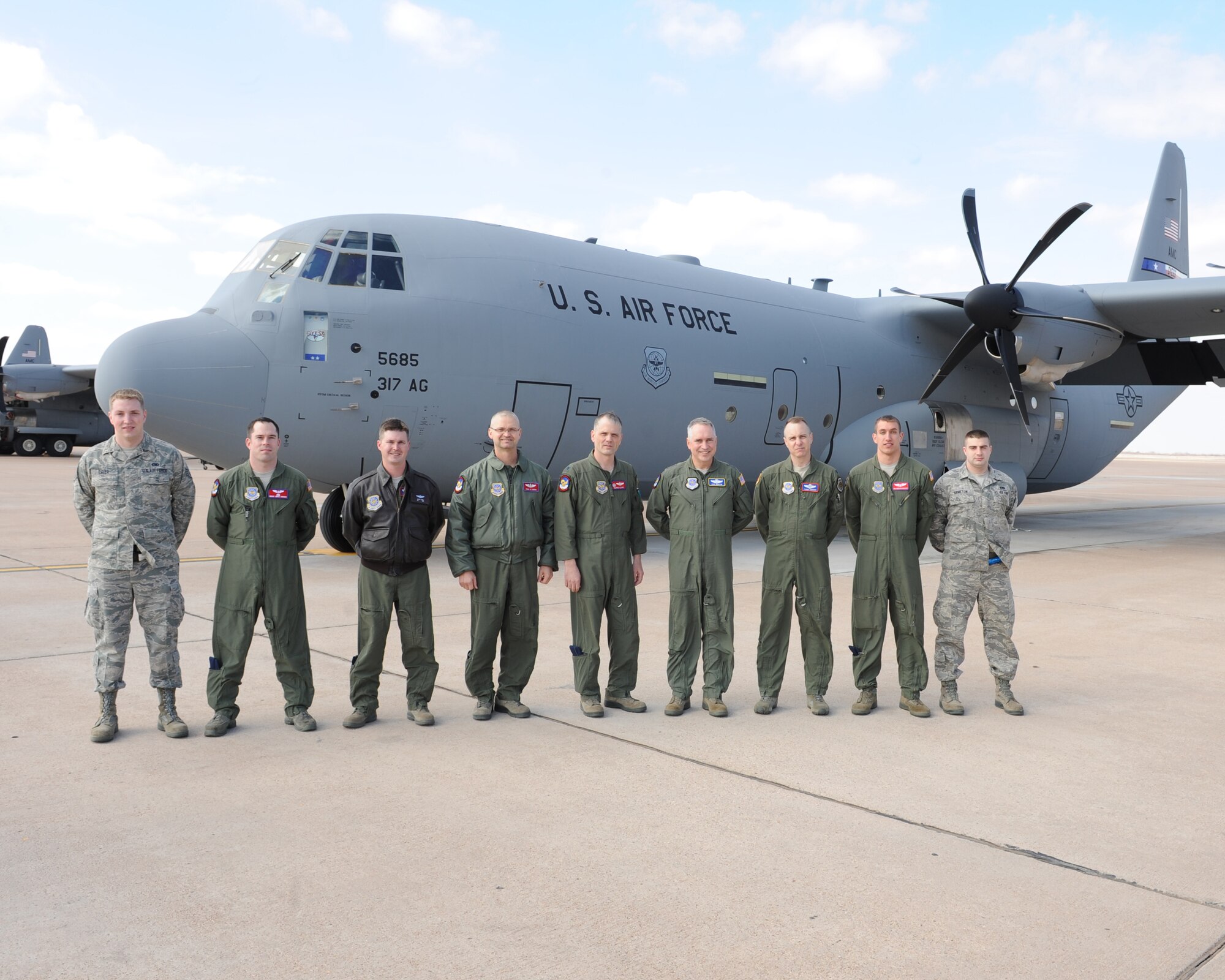 The crew of a new C-130 J-model gathers outside the aircraft Feb. 9, 2012, at Dyess Air Force Base, Texas. The aircraft is 14th of 28 J-models to be delivered to Dyess by 2013 and the first for the 39th Airlift Squadron. (U.S. Air Force photo by Airman 1st Class Peter Thompson/Released)