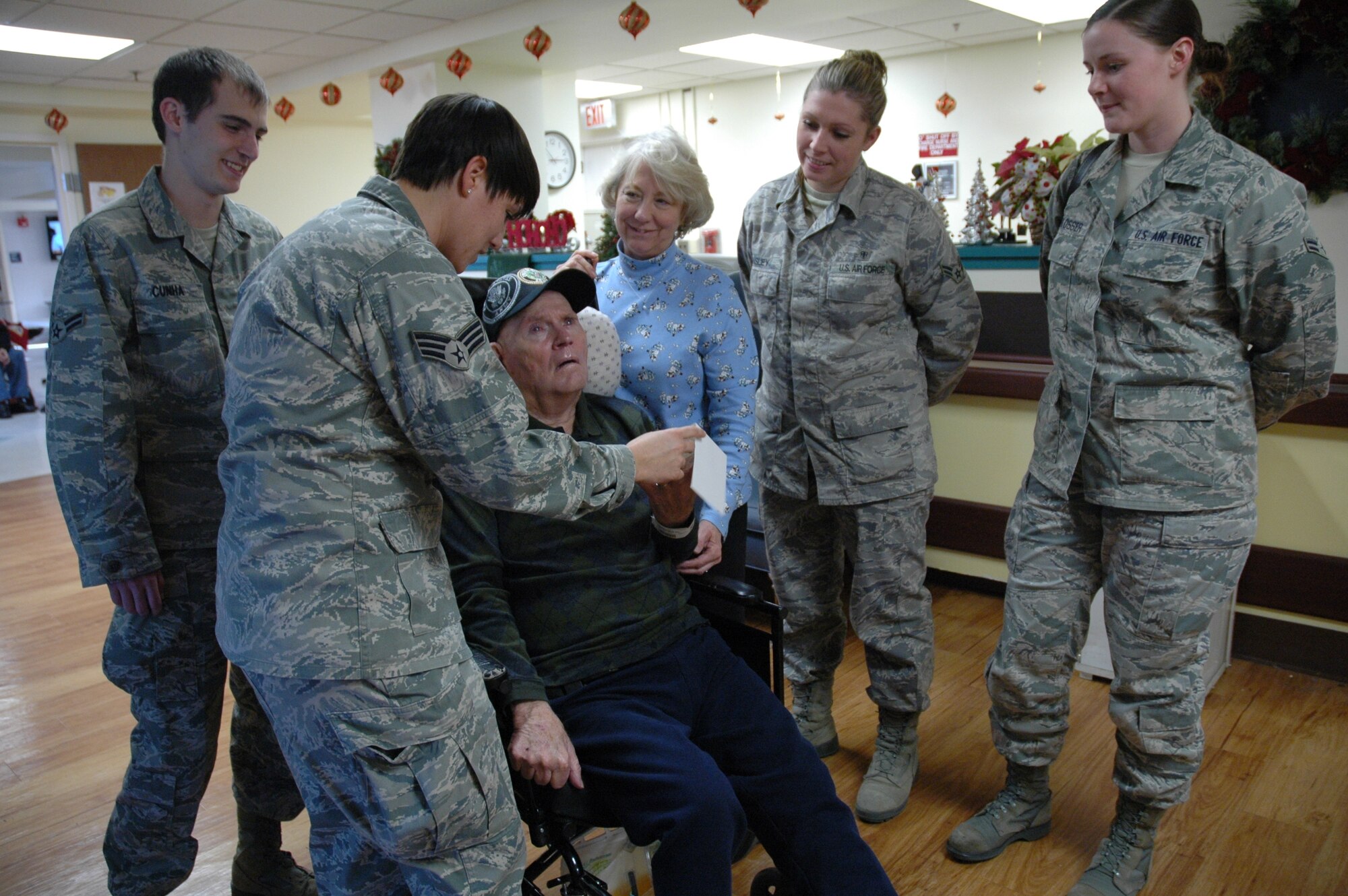 Retired U.S. Army Capt. Curtis Clark and wife Carol receive a visit from 4th Medical Group Airmen at the Community Living Center in Fayetteville, N.C., Jan. 2, 2012. Senior Airman Madison Harter, Airmen 1st Class Marco Cunha, Katelyn Tinsley and Jenai O’Blosser, along with seven other Airmen traveled from Seymour Johnson Air Force Base to thank retired veterans at the center for their service. (U.S. Air Force photo)