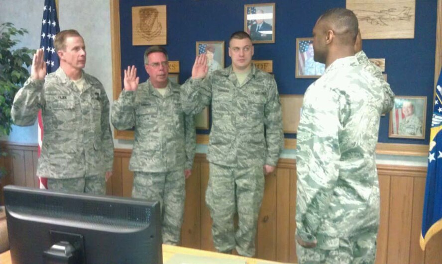 Tech. Sgt. Michael Flock (left), Master Sgt. Carl Cramer (center), and Tech. Sgt. Nathan Corrado (right) take the oath of enlistment from Capt. Jarius Wallace during the December drill weekend. All four are members of the 916th Maintenance Squadron. (USAF photo courtesy of 916MXS)