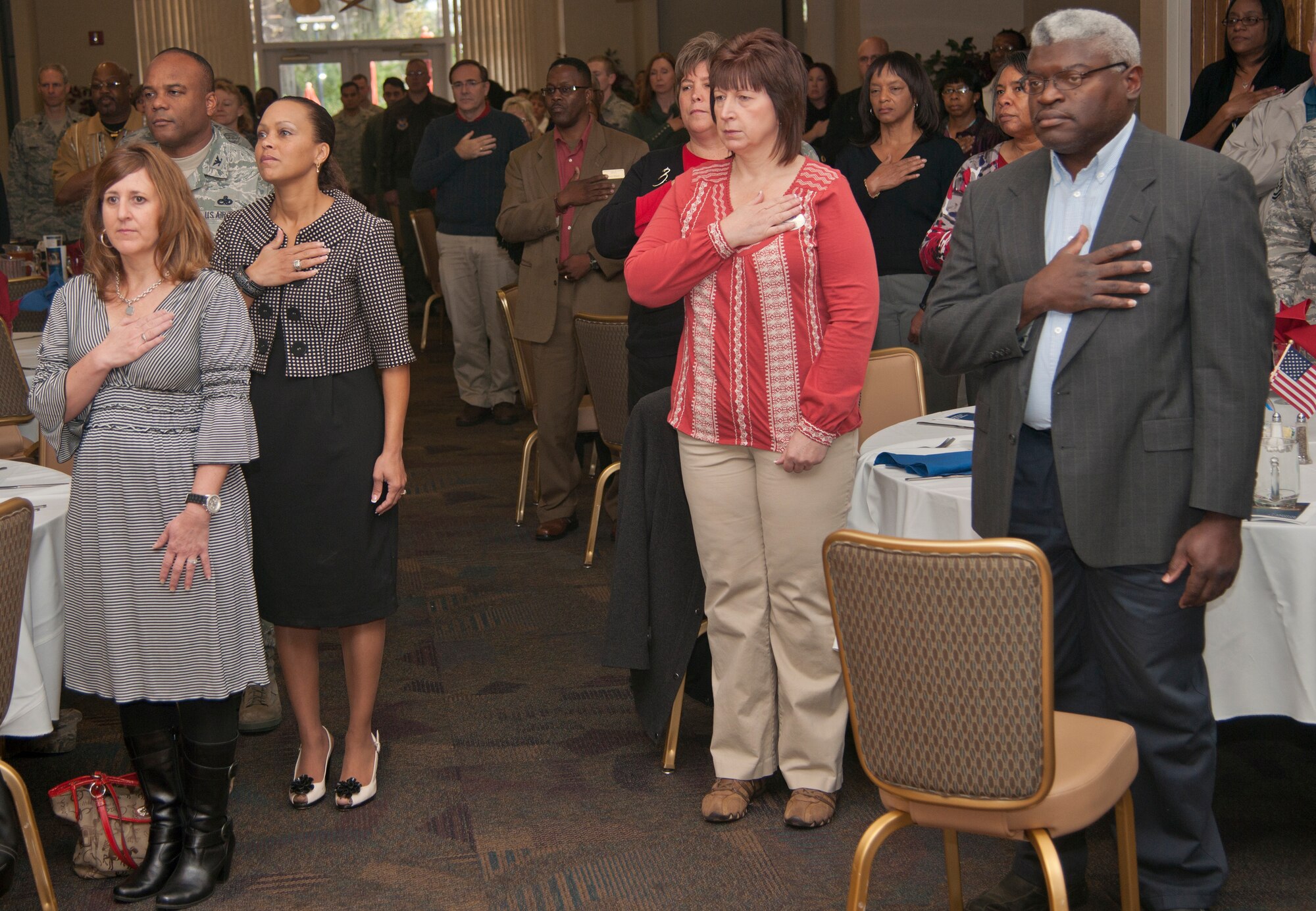 Team Moody members pay their respects during the posting of the colors during the National Prayer Luncheon at Moody Air Force Base, Ga., Feb. 9, 2012. The luncheon’s guest speaker was U.S. Air Force Chaplain (Brig. Gen.) Howard Stendahl, Air Force deputy chief of chaplains. (U.S. Air Force photo by Airman 1st Class Paul Francis/Released)
