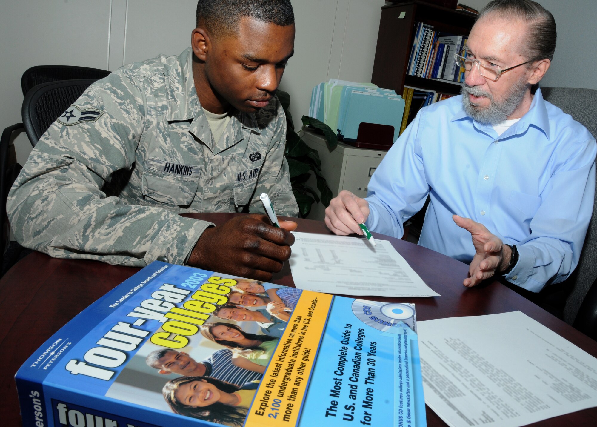 Harry Reichner, CSC education counselor, provides education mentoring to  Airman 1st Class Keith Hankins, 81st Training Wing, by reviewing progress toward his Community College of the Air Force degree Feb. 10, 2012, at the Sablich Center, Keesler Air Force Base, Miss.  (U.S. Air Force photo by Kemberly Groue)