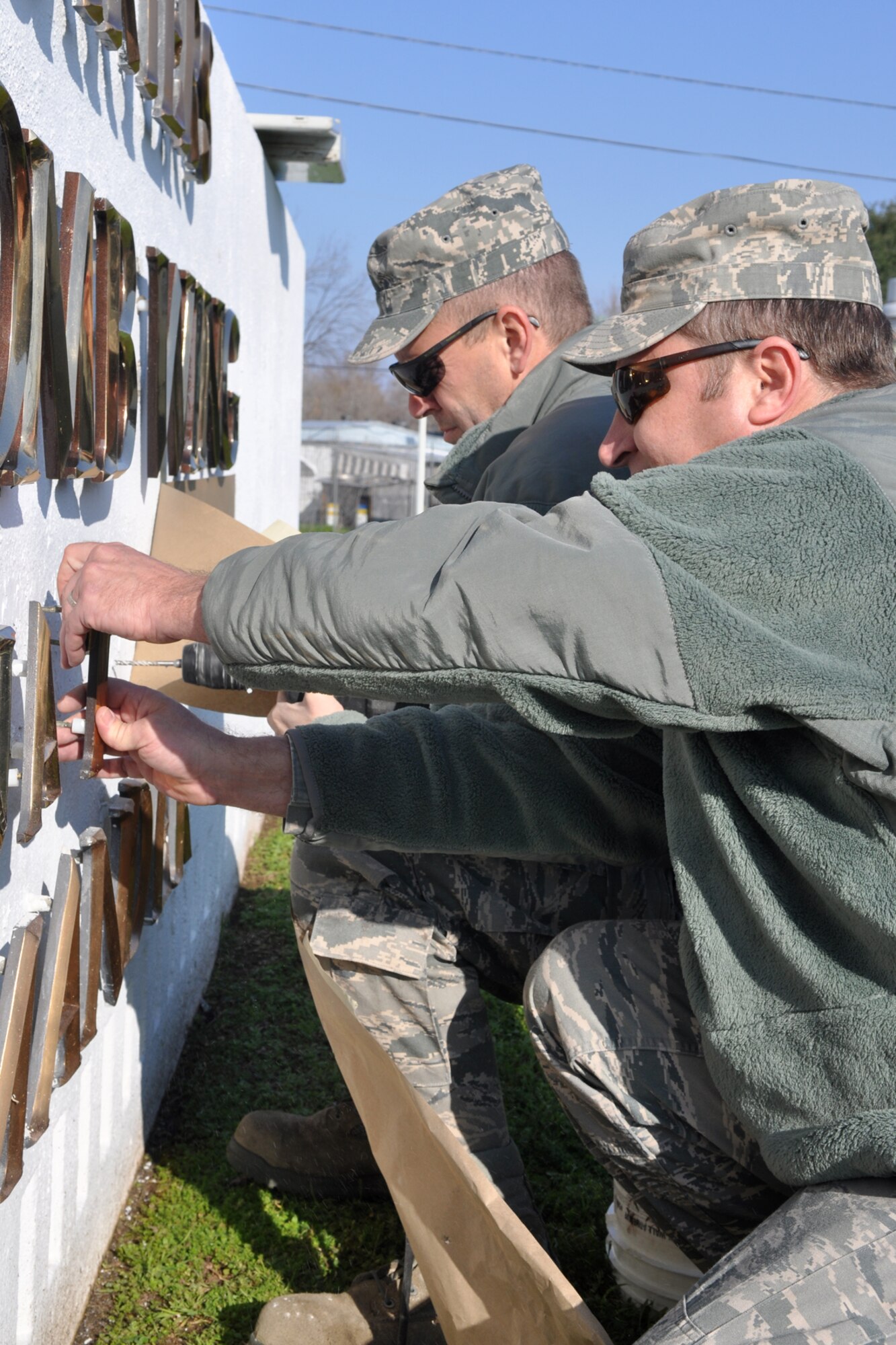 Senior Airman James Green, places a “new” letter into the 307th Bomb Wing Headquarters sign, as Tech. Sgt. Christopher Collins, drills holes for additional letters at Barksdale Air Force Base, La., Feb. 8, 2010. The name of the new commander is being placed in the sign ahead of change of command ceremonies scheduled for Feb 11, where Col. Jonathan M. Ellis, will take the reins of the 307th BW from Brig. Gen. John J. Mooney III. Ellis is coming to the 307th BW from Beale Air Force Base, Calif., where he was the commander of the 940th Operations Group. Mooney is headed to Air Force Reserve Command Headquarters at Robins Air Force Base, Ga., where he will take on responsibilities as the Inspector General. Green, a utilities systems technician, and Collins, an electrical power production technician, are assigned to the 307th Civil Engineer Squadron. (U.S. Air Force photo by Master Sgt. Jeff Walston)