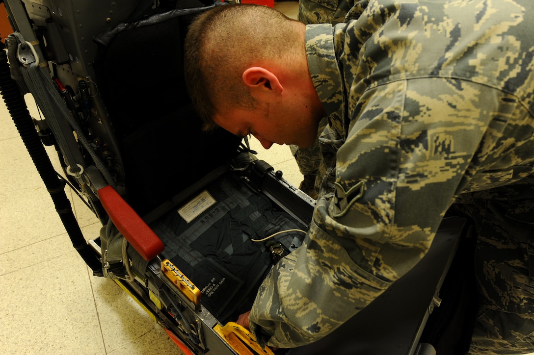 Airman Calvin Daniels, 28th Maintenance Squadron aircrew egress system apprentice, installs a survival kit in an Advance Concept Ejection Seat II during training at Ellsworth Air Force Base, S.D., Jan. 23, 2012. The survival kit supplies aircrew members with necessary items to help sustain them until rescuers arrive. (U.S. Air Force photo by Airman 1st Class Zachary Hada/Released)