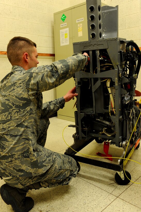 Airman Calvin Daniels, 28th Maintenance Squadron aircrew egress system apprentice, adjusts the drogue gun on an Advance Concept Ejection Seat II on Ellsworth Air Force Base, S.D., Jan. 23, 2012. All parts on the ACES II are thoroughly checked by egress Airmen daily to maintain the equipment’s functionality. (U.S. Air Force photo by Airman 1st Class Zachary Hada/Released)