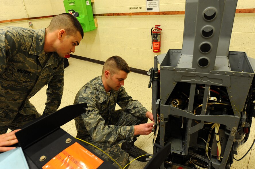 Senior Airman Timothy Milders and Airman Calvin Daniels, 28th Maintenance Squadron aircrew egress system technicians, install safety pins and arm straps onto an Advance Concept Ejection Seat II during training at Ellsworth Air Force Base, S.D., Jan. 23, 2012.There are four ACES II installed in every B-1B. (U.S. Air Force photo by Airman 1st Class Zachary Hada/Released)