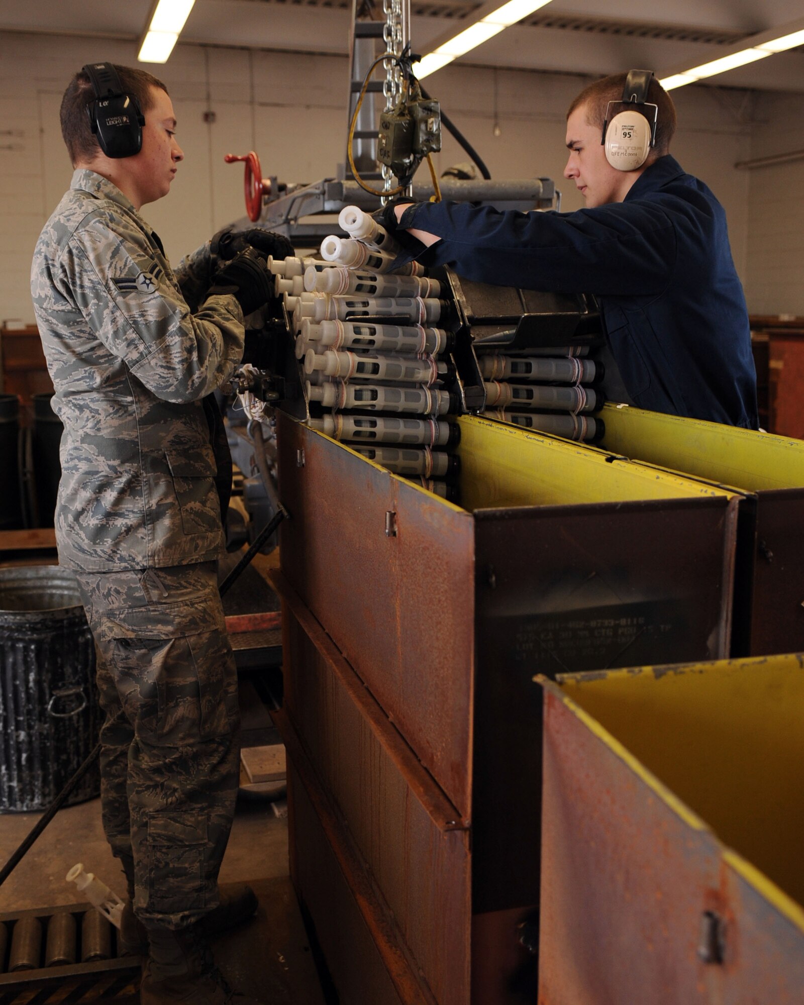 U.S Air Force Airman 1st Class Zackary Crabb, 355th Equipment Maintenance Squadron, and Airman 1st Class Jordan Shepherd, 355th Equipment Maintenance Squadron, feeds 30mm of ammo onto the GFU-7 rail system on Davis-Monthan Air Force Base, Ariz., Feb. 8, 2012. (U.S. Air Force photo by Airman 1st Class Christine Griffiths/Released) 