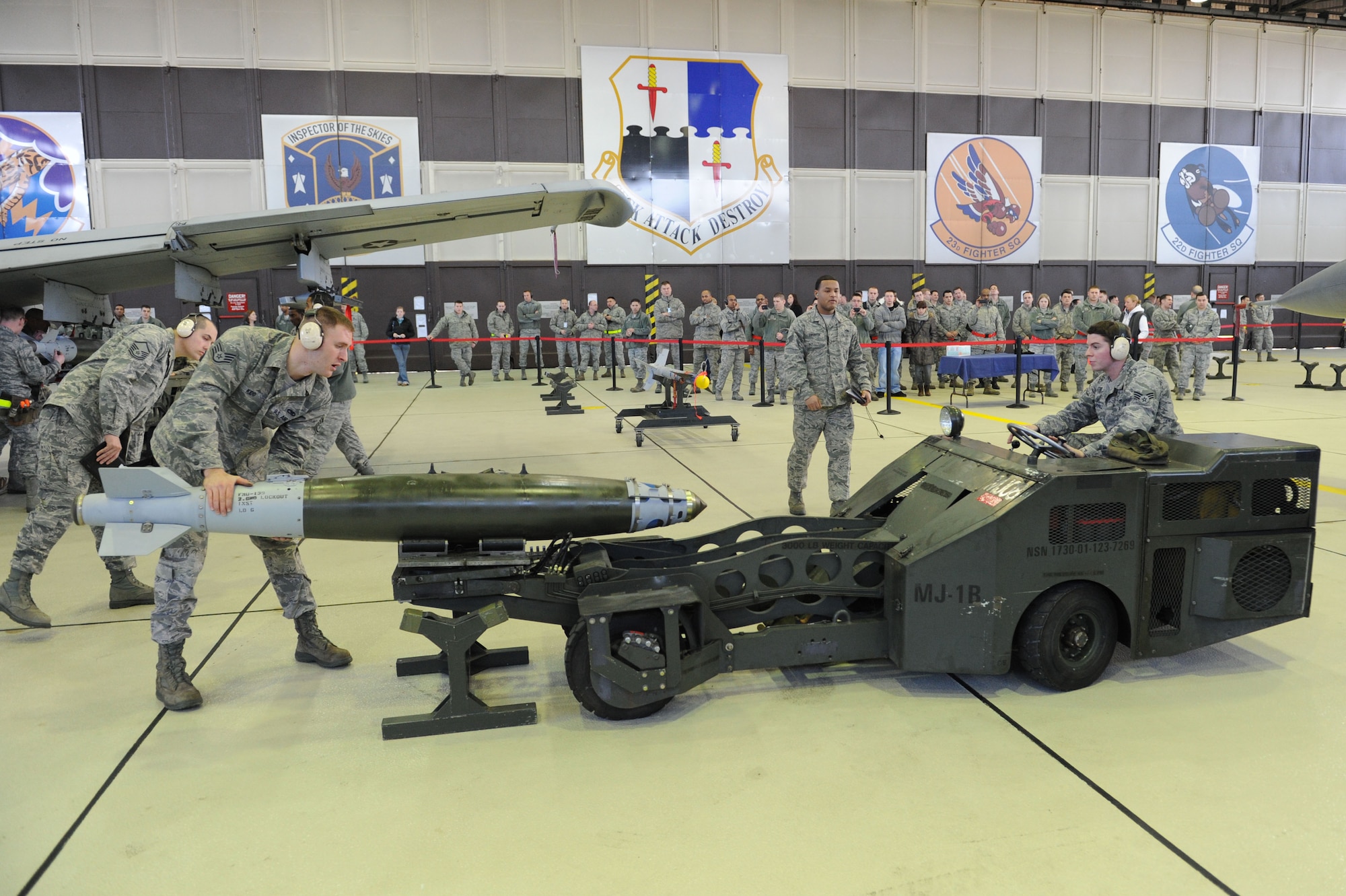 SPANGDAHLEM AIR BASE, Germany – Staff Sgt. Joshua Kidd, 480th Aircraft Maintenance Unit weapon load crew member, guides Senior Airman Larry Shimmell, 480th Aircraft Maintenance Unit weapon load crew member, while he uses an MJ-1 Jammer to pick up a GBU-38 bomb during the load crew of the year competition at Hangar 1 here Feb. 10. Each of the three load crews won a quarterly competition to participate in this event.  The winner will be announced at the wing annual awards March 9and will represent Spangdahlem AB in a U.S. Air Forces in Europe load crew competition later this year. The 81st and 480th AMUs maintain aircraft that deliver precise, full-spectrum capability for the current fight. (U.S. Air Force photo by Senior Airman Christopher Toon/Released)



