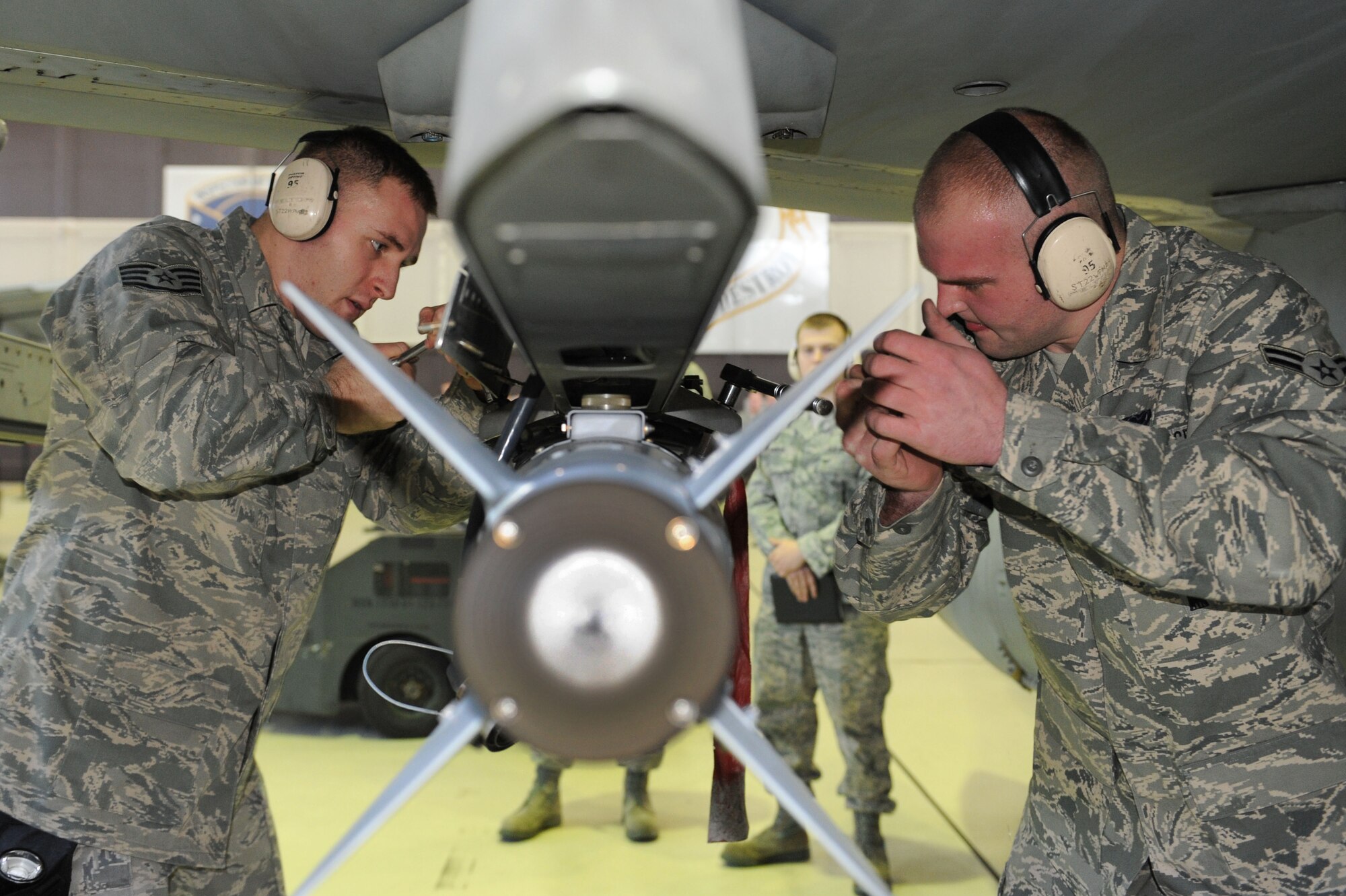 SPANGDAHLEM AIR BASE, Germany – Staff Sgt. Joshua Kidd and Airman 1st Class Justin McKay, 480th Aircraft Maintenance Unit weapon load crew members, secure a GBU-38 bomb to an F-16 Fighting Falcon during the load crew of the year competition at Hangar 1 here Feb. 10. Each of the three load crews won a quarterly competition to participate in this event.  The winner will be announced at the wing annual awards March 9 and will represent Spangdahlem AB in a U.S. Air Forces in Europe load crew competition later this year. The 81st and 480th AMUs maintain aircraft that deliver precise, full-spectrum capability for the current fight. (U.S. Air Force photo by Senior Airman Christopher Toon/Released)