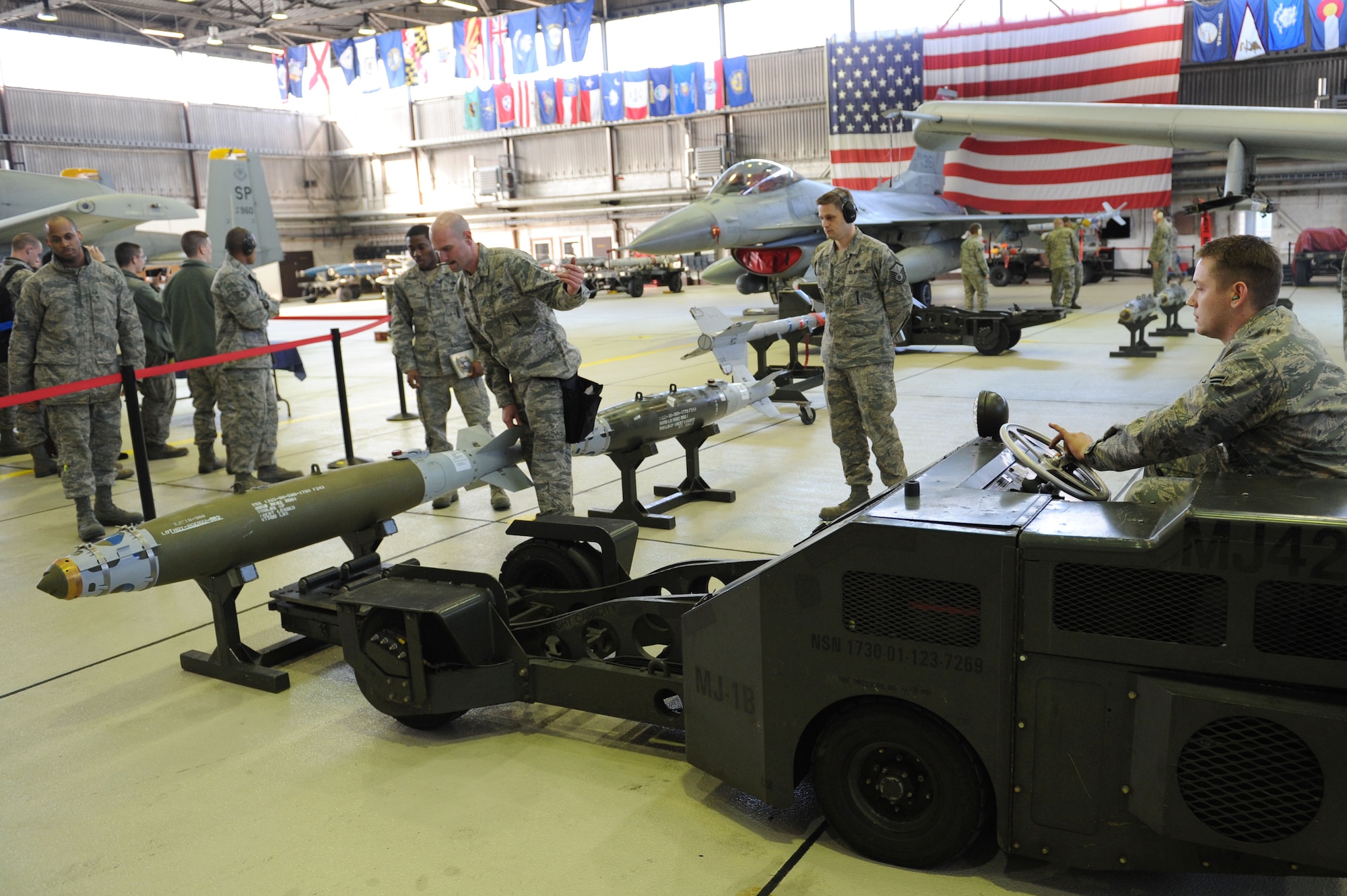 SPANGDAHLEM AIR BASE, Germany – Staff Sgt. Matthew Bonney, 81st Aircraft Maintenance Unit weapon load crew chief, guides Senior Airman Forrest Womack, 81st AMU weapon load crew member, while he uses an MJ-1 Jammer to pick up a GBU-38 bomb during the load crew of the year competition at Hangar 1 here Feb. 10. Each of the three load crews won a quarterly competition to participate in this event.  The winner will be announced at the wing annual awards March 9 and will represent Spangdahlem AB in a U.S. Air Forces in Europe load crew competition later this year. The 81st and 480th AMUs maintain aircraft that deliver precise, full-spectrum capability for the current fight. (U.S. Air Force photo by Senior Airman Christopher Toon/Released)