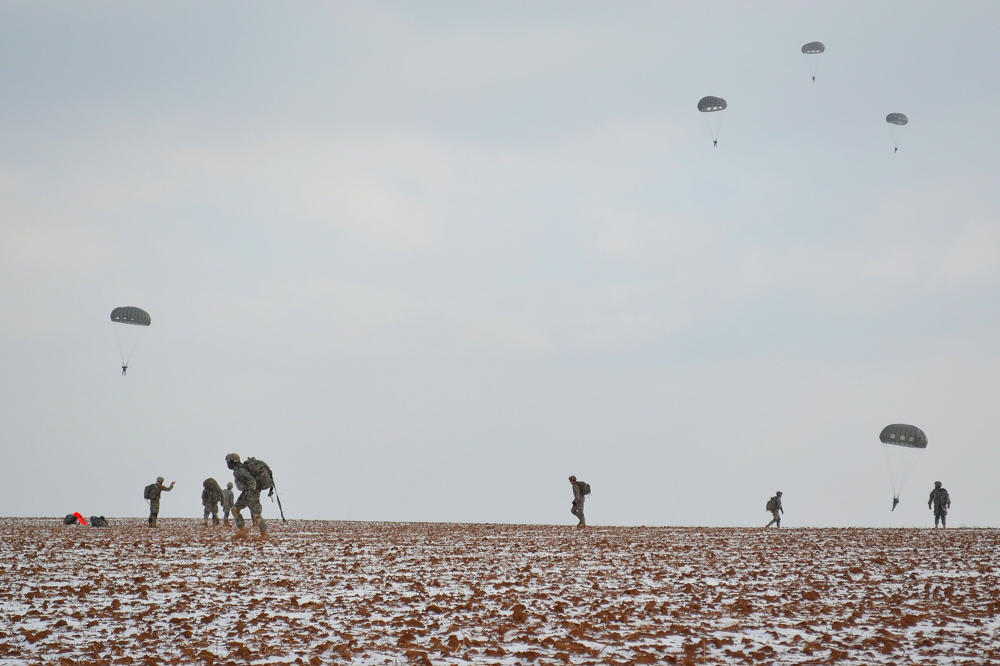 U.S. Army paratroopers from the 173rd Airborne Brigade Combat Team, out of Aviano Air Base, Italy, participate in airfield seizure operations during the 37th Airlift Squadron 70th Anniversary event, Feb. 10, 2012. Paratroopers help line up rucksacks after being dropped from U.S. Air Force C-130J Super Hercules assigned to the 37th Airlift Squadron, Ramstein Air Base, Germany. (U.S. Air Force photo by Airman 1st Class Holly Cook)

