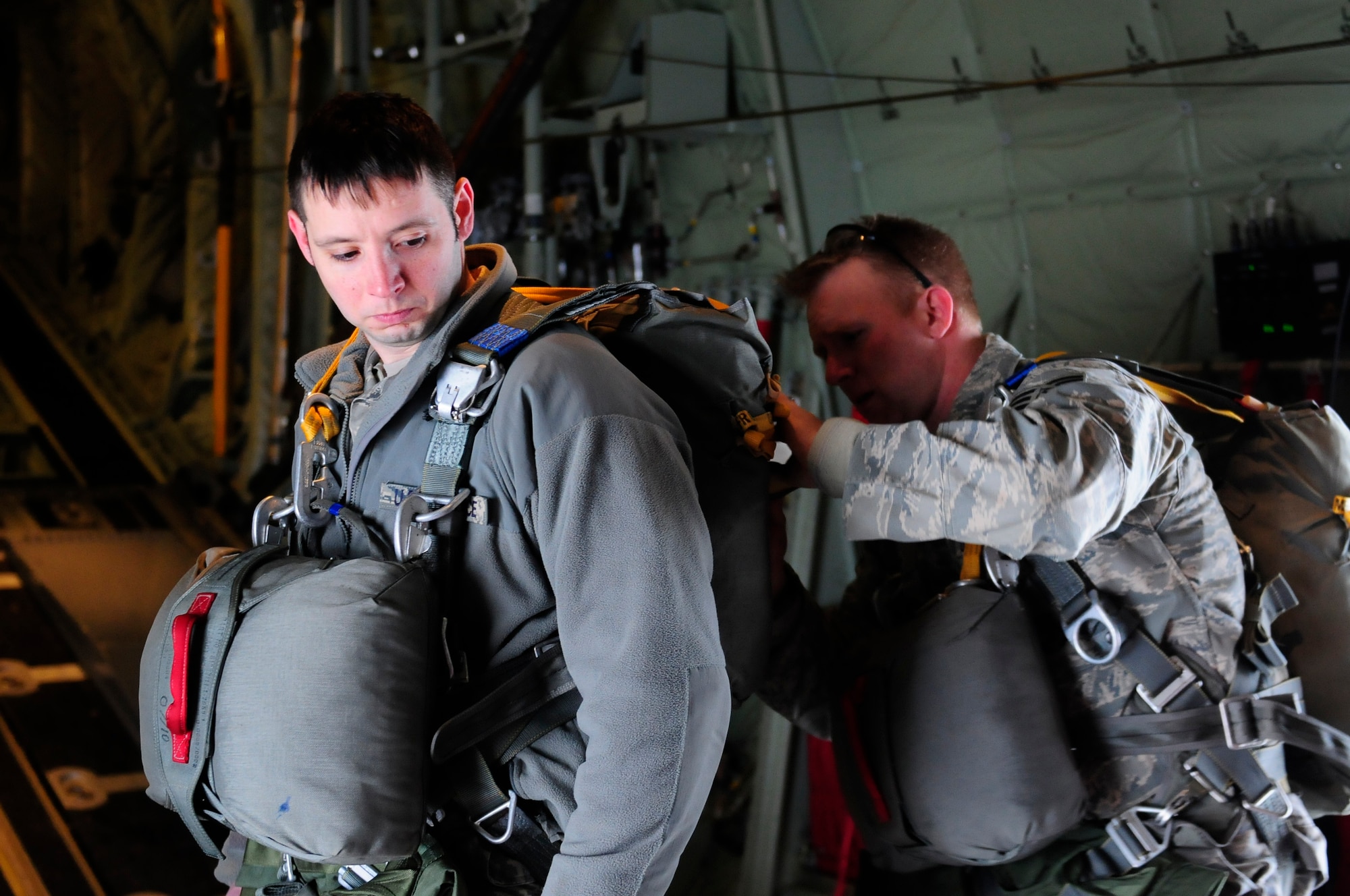 Tech. Sgt. Johnny Gaunt checks Tech Sgt. Derrick Drennan's parachute harnes, both Jump Masters from the 435th Security Forces Squadron, for safety during a mass airdrop with the 37th Airlift Squadron in Alzey, Germany, February 10, 2012. The mass airdrop commemorated 7o years of combat airlift capabilities for the 37th AS. (U.S. Air Force photo by Airman 1st Class Kendra Alba)