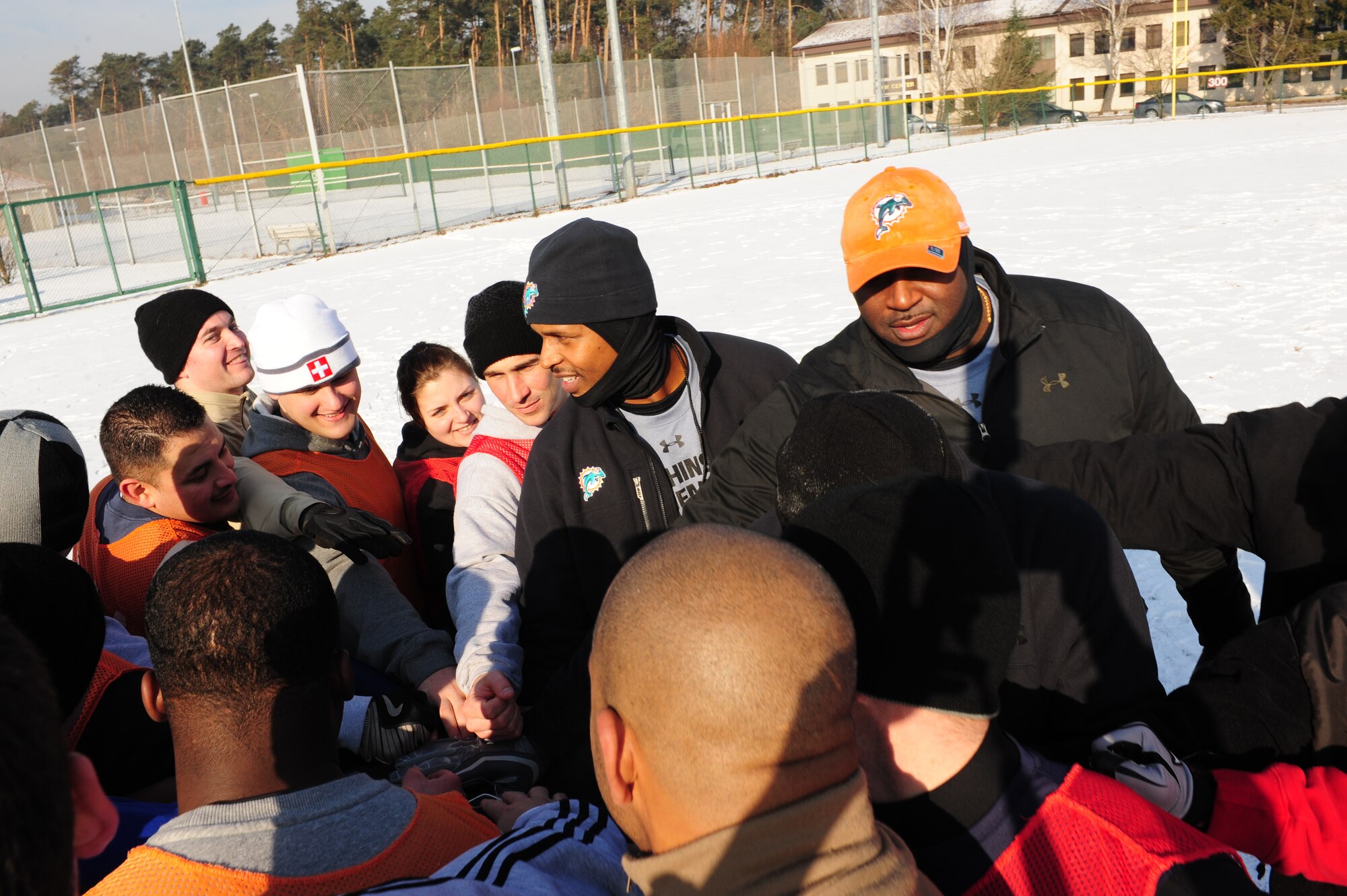 Former Miami Dolphin football players and Military members congratulate each other after a game of flag football together as part of an Armed Forces Entertainment tour, Ramstein Germany, Feb 09, 2012. Former members from the Miami Dolphins and six of their cheerleaders came here to visit with troops and throw down on a little flag football and show their appreciation for the service of the U.S. Armed Forces. (U.S. Air Force photo by Senior Airman Aaron-Forrest Wainwright)