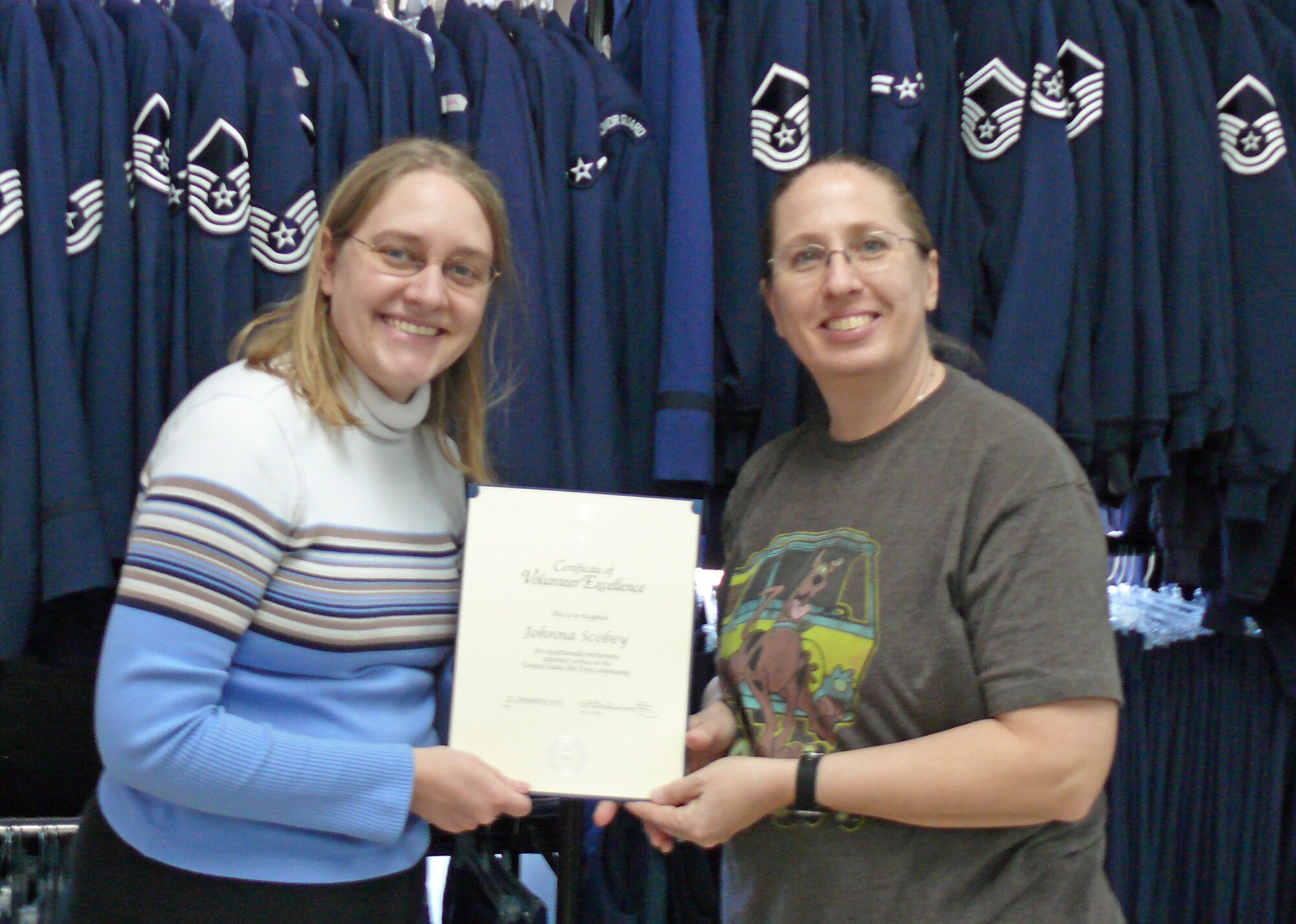 Beth Campbell (left), Airman and Family Readiness Center volunteer manager, presents the 2011 Volunteer Excellence Award to Johnna Scobey, the volunteer manager of the Airman's Attic, Feb. 1. Scobey spends about 30 hours each week managing the Airman’s Attic. (U.S. Air Force photo/Mel Castille)
