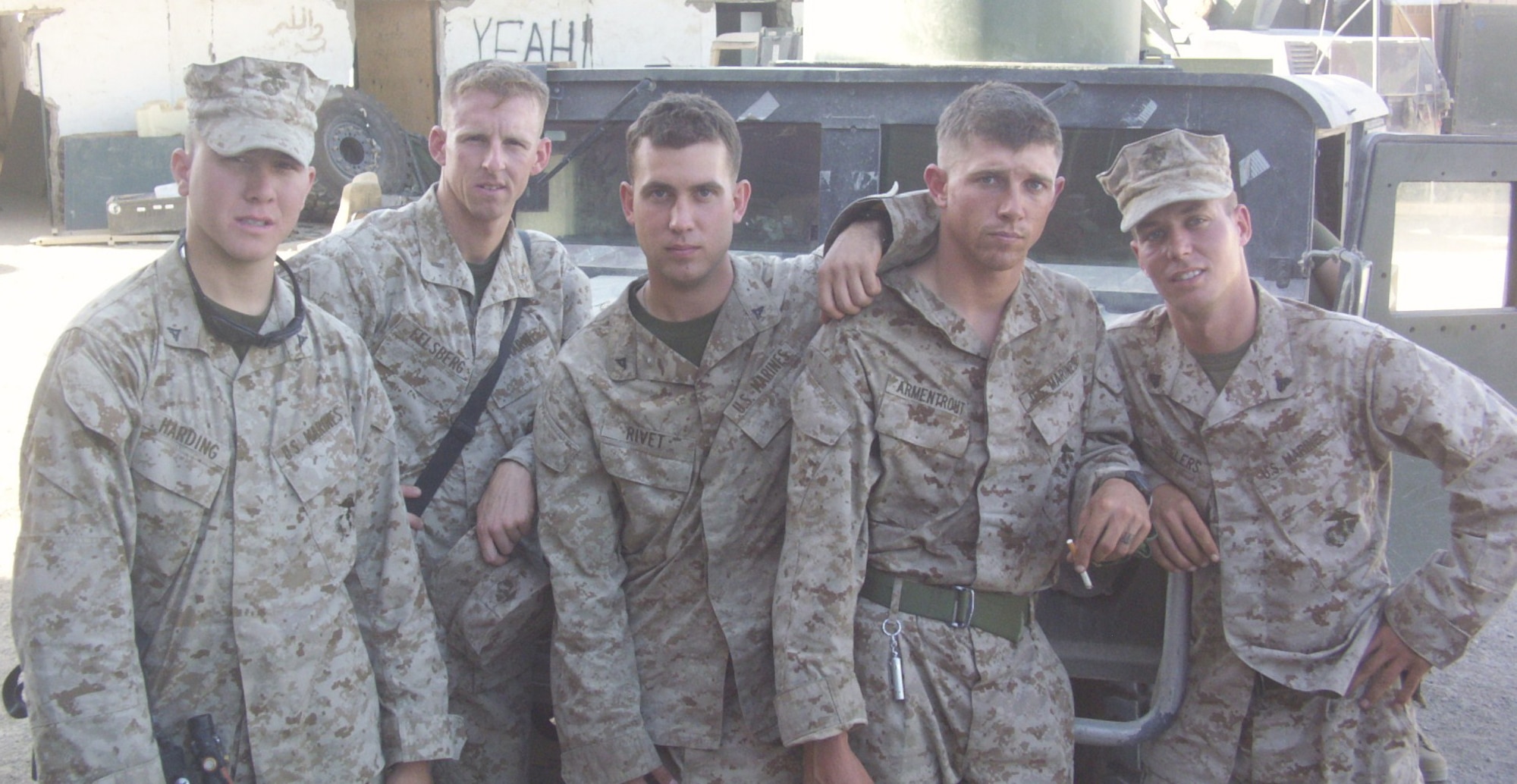 Former Marine Sgt. Brian Sellers (right) stands with fellow Marines in front of a humvee that was destroyed in an improvised explosive device blast while deployed to Camp Ramadi, Iraq in 2004. Sellers was a vehicle commander with Echo Company, 2nd Battalion, 5th Marines. (courtesy photo)