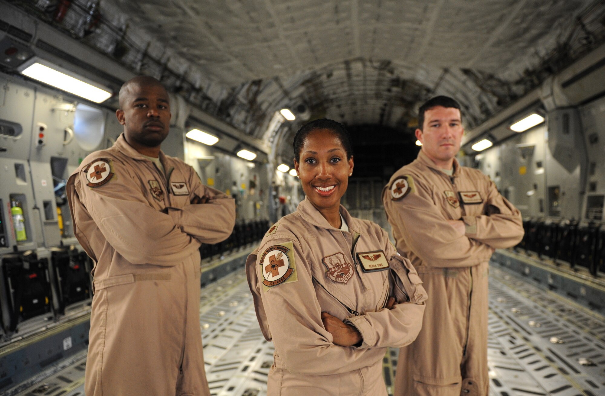 (From left) – Staff Sgt. Donald Ennis, a 379th EAES medical technician and Washington, D.C., native, Maj. Debra Sims, 379th Expeditionary Aeromedical Evacuation Squadron flight nurse and Dallas native, Staff Sgt. Richard Brampton, a 379th EAES medical technician and Camano Island, Wash., native, stand inside a C-17 Globemaster here Feb. 10, 2012. The C-17 is the same aircraft the three Airmen used while executing a priority evacuation mission of hostages rescued from Somalia. (U.S. Air Force photo/Staff Sgt. Nathanael Callon)