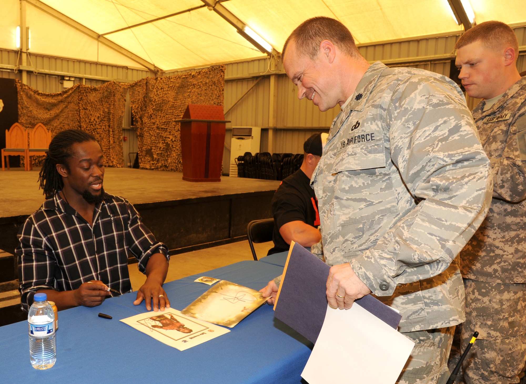 SOUTHWEST ASIA - Lt. Col. Steven Breitfelder gets an autograph from World Wrestling Entertainment superstar Kofi Kingston during a USO visit Feb. 10, 2012. The wrestlers took photos and signed autographs with more than 200 Airmen and Soldiers assigned to the 380th Air Expeditionary Wing. (U.S. Air Force photo/Tech. Sgt. Arian Nead)