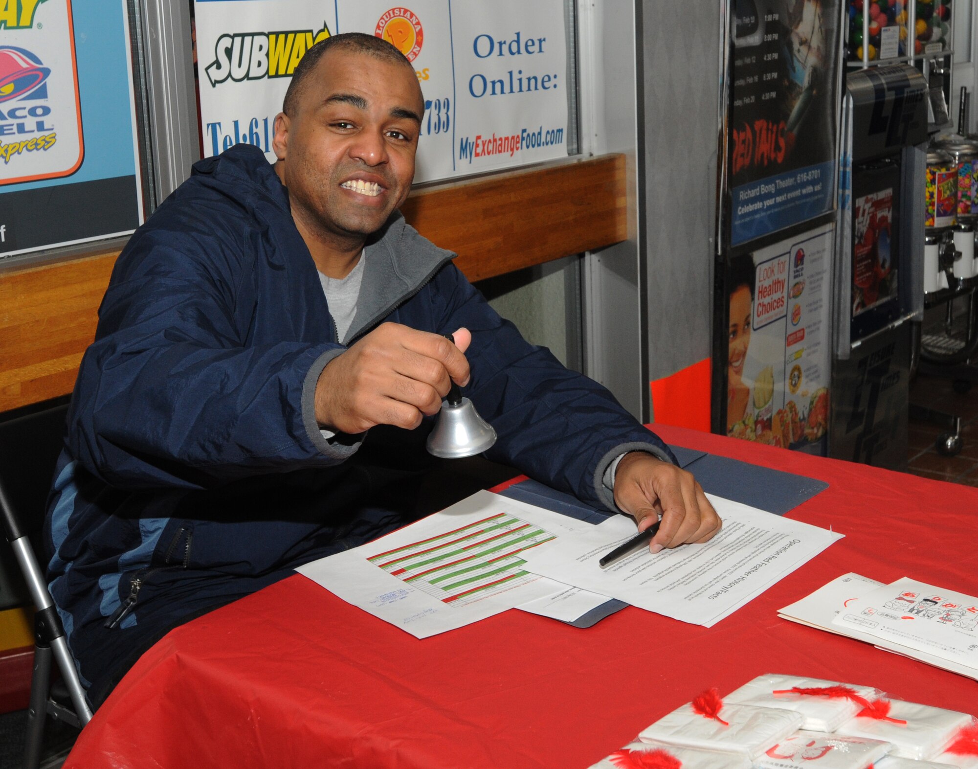 MISAWA AIR BASE, Japan – Tech. Sgt. James Jordan, 35th Force Support Squadron installation personnel readiness NCO officer in charge, volunteers at the Exchange here, Feb. 9 for the Red Feather Campaign. Ninety percent of funds collected during the campaign will remain in Aomori Prefecture, Japan. The other 10 percent will go to national programs. (U.S. Air Force photo/Airman Kenna Jackson)