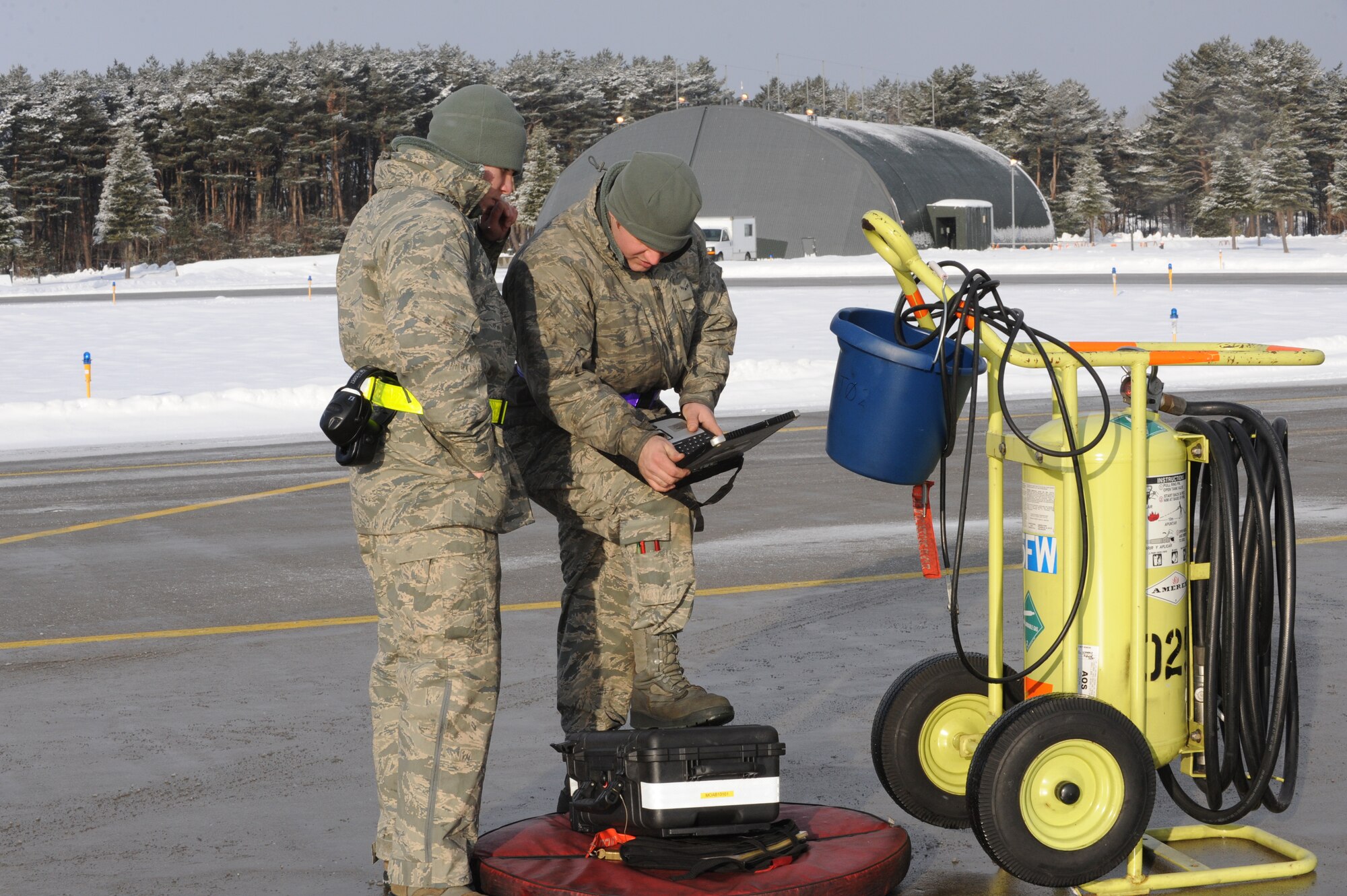 MISAWA AIR BASE, Japan – Airmen 1st Class Mark Ward, left, and Christopher Bailey, 14th Aircraft Maintenance Unit crew chiefs, read their technical orders to inspect an aircraft before its launch here, Jan. 24. It is mandatory for all maintainers to follow their TOs step-by-step regardless of their rank or experience. (U.S. Air Force photo/Airman Kenna Jackson)