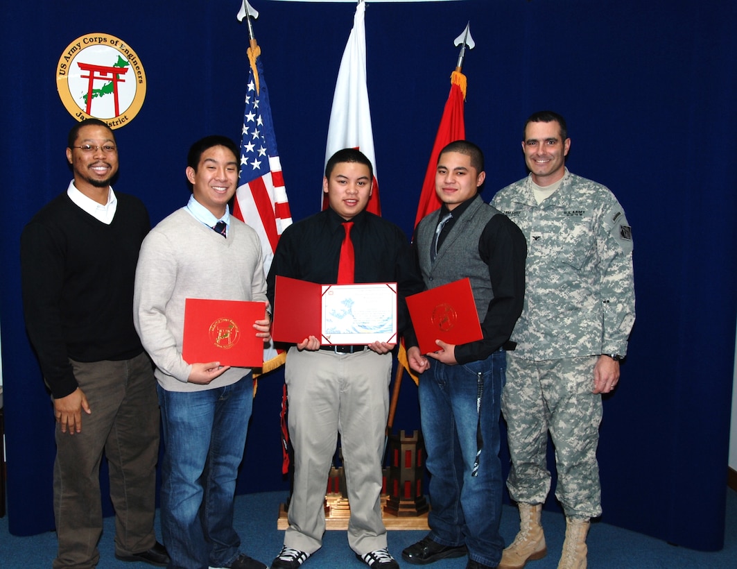 Cedric Bazemore, Japan District engineer, left, and Colonel Bryan P. Truesdell, Japan District Commander, stand with Team GAS members Stephen Ferrer, Arvin Cortez and Gabriel Malate.  The colonel congratulated the 2011 champions and presented each with a certificate and commander’s coin to commemorate their victory in Bid Estimation Project 2011.