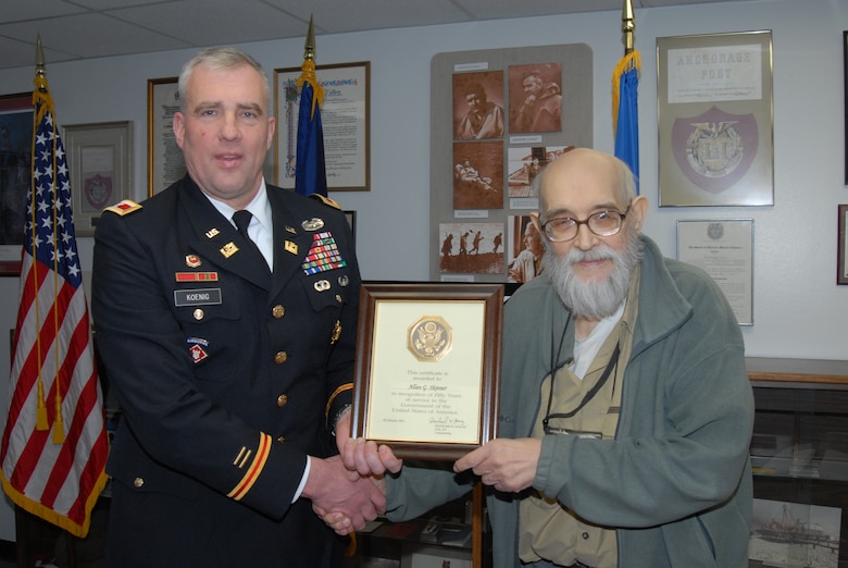 U.S. Army Corps of Engineers Alaska District Commander Col. Reinhard W. Koenig presents Allan Skinner with a certificate for 50 years of federal service.