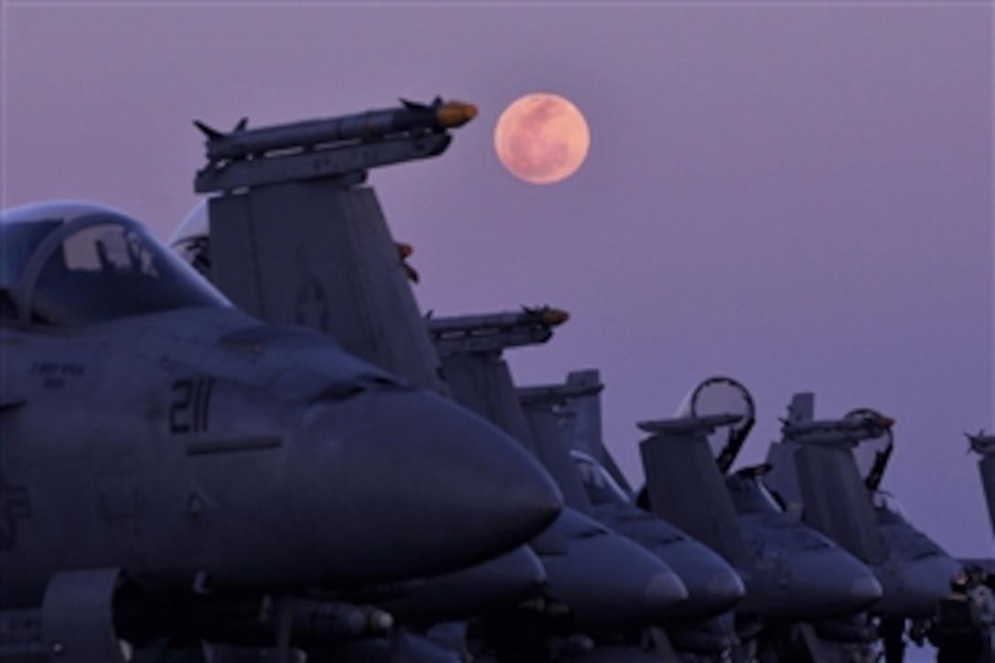 The moon rises over aircraft on the flight deck aboard the aircraft carrier USS Carl Vinson (CVN 70) in the Arabian Sea on Feb. 8, 2012.  