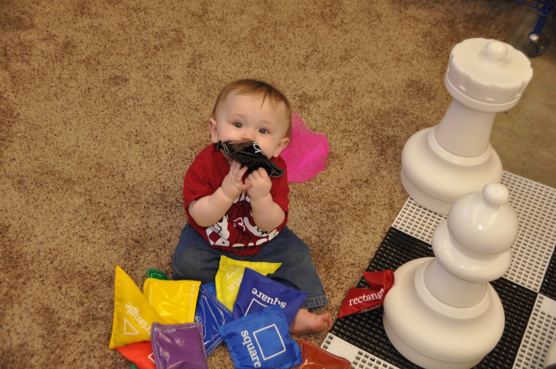During the Feb. 10 grand opening of the multipurpose room in building 375 aboard Marine Corps Logistics Base Barstow, little Ronin Mallett disdains the giant chess pieces in favor something he can actually get into his mouth Feb. 10.