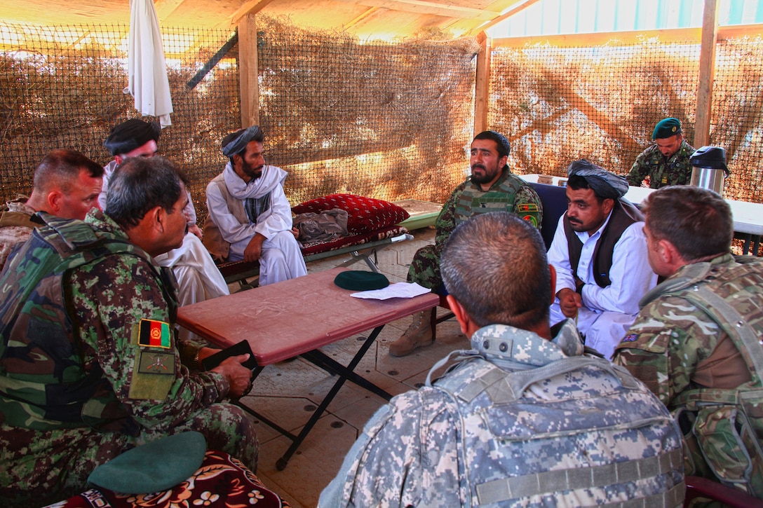 Afghan National Army troops from the 215th Corps and local Washir district, Helmand province, government officials sit down during a shura with local Afghans in the district, August 19. During the shura the Afghans talked about local crime and putting an end to it.