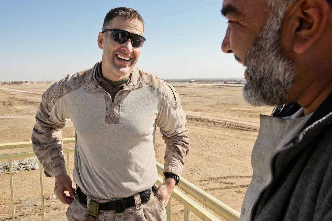 Maj. Erich Beriel candidly talks with Abdul Rahman, renewable energy engineer, who installed the solar panels on top of the new Marjeh Fruit and Vegetable Packing Facility. The solar panel-powered renewable energy system is capable of delivering 12,000 watts of electricity and cooling the building down 40 degrees Farenheit. 