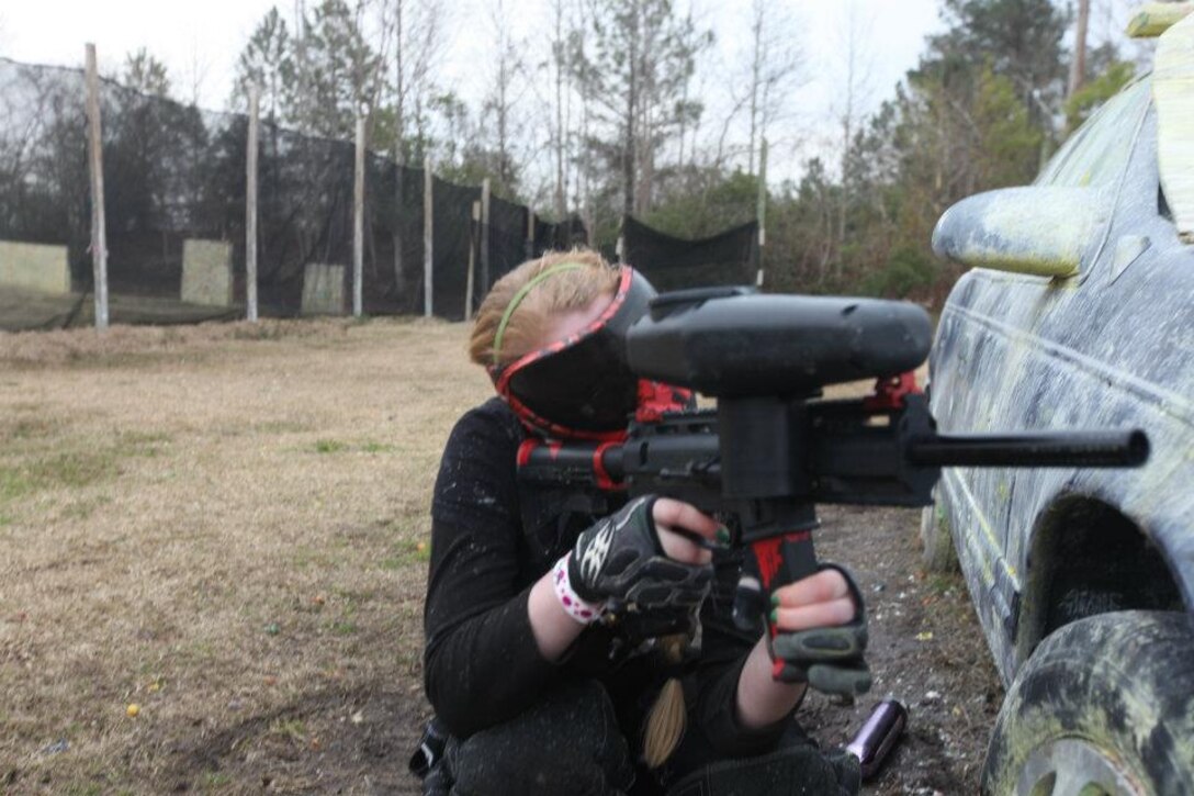 A female paintballer tries to aim down her sights and hit someone with a paintball during a normal weekend of paintballing in Jacksonville, N.C.. Paintball can be enjoyed by anyone who likes fast, action-packed sports.