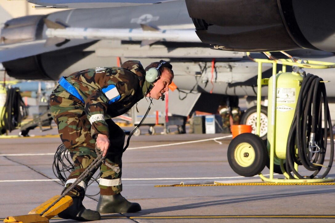 U.S. Air Force Staff Sgt. Eric Skogen, 140th Operations Group, removes a set of wheel blocks from an F-16 Fighting Falcon before a flight during an Operational Readiness at Buckley Air Force Base Colo., Jan. 20, 2012. Buckley Air National Guard airmen are taking part in the ORE being held on base throughout the weekend. The exercise evaluates airmen with mission readiness in preparation for real world deployments as well as an inspection later this spring. (U.S. Air Force photo by Wolfram M. Stumpf /RELEASED)