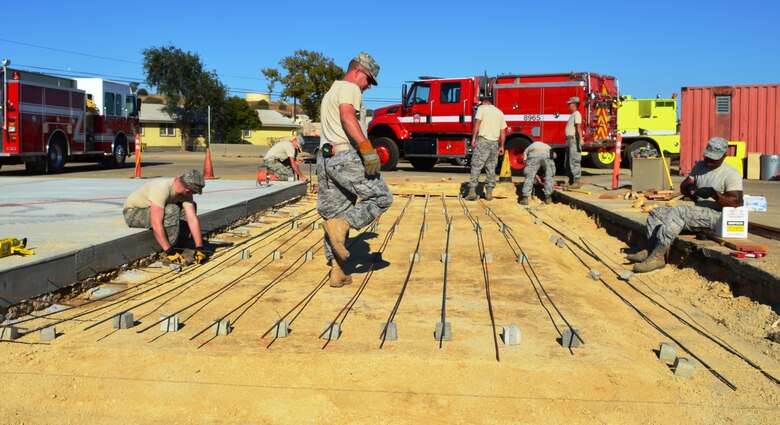175th Civil Engineer Squadron members tie rebar into place for a concrete pad for a fire truck. During a deployment for training, the 175th CES of the Maryland Air National Guard supported the California Army National Guard at Camp Roberts by constructing a concrete pad for the fire station, three range towers and renovating a dormitory. (National Guard photo by Staff Sgt. Tabitha Gomes)