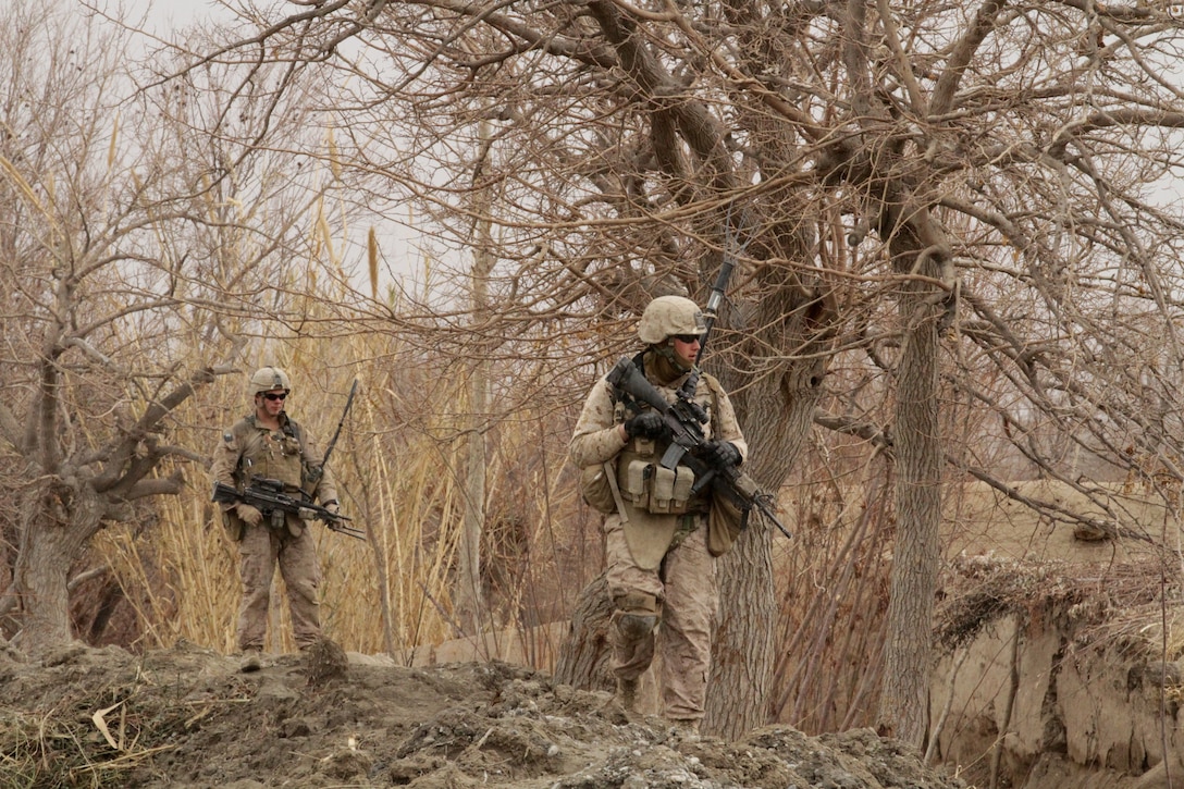 Lance Cpl. Dakota M. Landrie (left), an automatic rifleman with India Company, 3rd Battalion, 7th Marine Regiment, and Lance Cpl. William M. Baldridge (right), a radio operator with, India Co., patrol here recently. Landrie, a 19-year-old native of Indian Land, S.C., and 2010 graduate of Indian Land High School, and Baldridge, a 22-year-old native of Palmdale, Calif., traversed steep terrain to take a new route to the surrounding farmland.