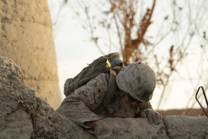 Petty Officer 3rd Class Anthony M. D. Balles, a line corpsman with, India Company, 3rd Battalion, 7th Marine Regiment, scales a wall during a security patrol here recently. Balles, a 22-year-old native of Kenosha, Wis., and 2008 graduate of Indian Trail Academy, taught a first aid class to Afghan National Army soldiers living at his patrol base.
