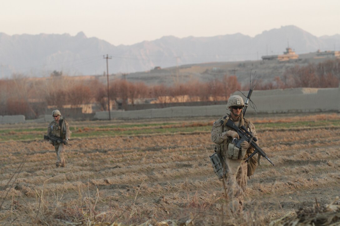 Lance Cpl. Christopher R. Maroney (left), a fire team leader and designated marksman with India Company, 3rd Battalion, 7th Marine Regiment, and Lance Cpl. Dakota M. Landrie, automatic rifleman with India Co., return from a security patrol in Barakzai recently. Maroney, a 22-year-old native of Pueblo, Colo., and 2008 graduate of Pueblo County High School, and Landrie, a 19-year-old native of Indian Land, S.C., and 2010 graduate of Indian Land High School, were deployed to Afghanistan since September 2011. Afghan National Army soldiers and Marines cleared the area of insurgents during the past two years and developed positive relations with local villagers.
