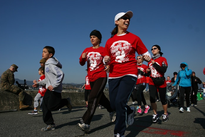 Station members begin the first Couples and Lonely Hearts Race hosted by the Iwakuni Roadrunners by beginning the first leg of the race at the start of the seawall behind the IronWorks Gym here Feb. 12. Club members got a free Couples and Lonely Hearts Race t-shirt and were able to run the race for free, along with any of the other races held by the club while other running enthusiasts had to pay a small fee to participate .