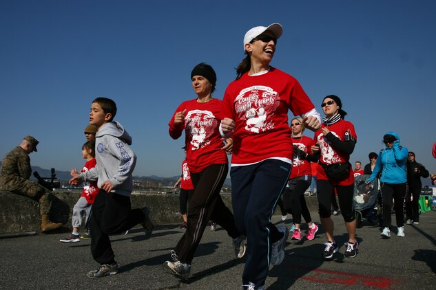 Station members begin the first Couples and Lonely Hearts Race hosted by the Iwakuni Roadrunners by beginning the first leg of the race at the start of the seawall behind the IronWorks Gym here Feb. 12. Club members got a free Couples and Lonely Hearts Race t-shirt and were able to run the race for free, along with any of the other races held by the club while other running enthusiasts had to pay a small fee to participate .