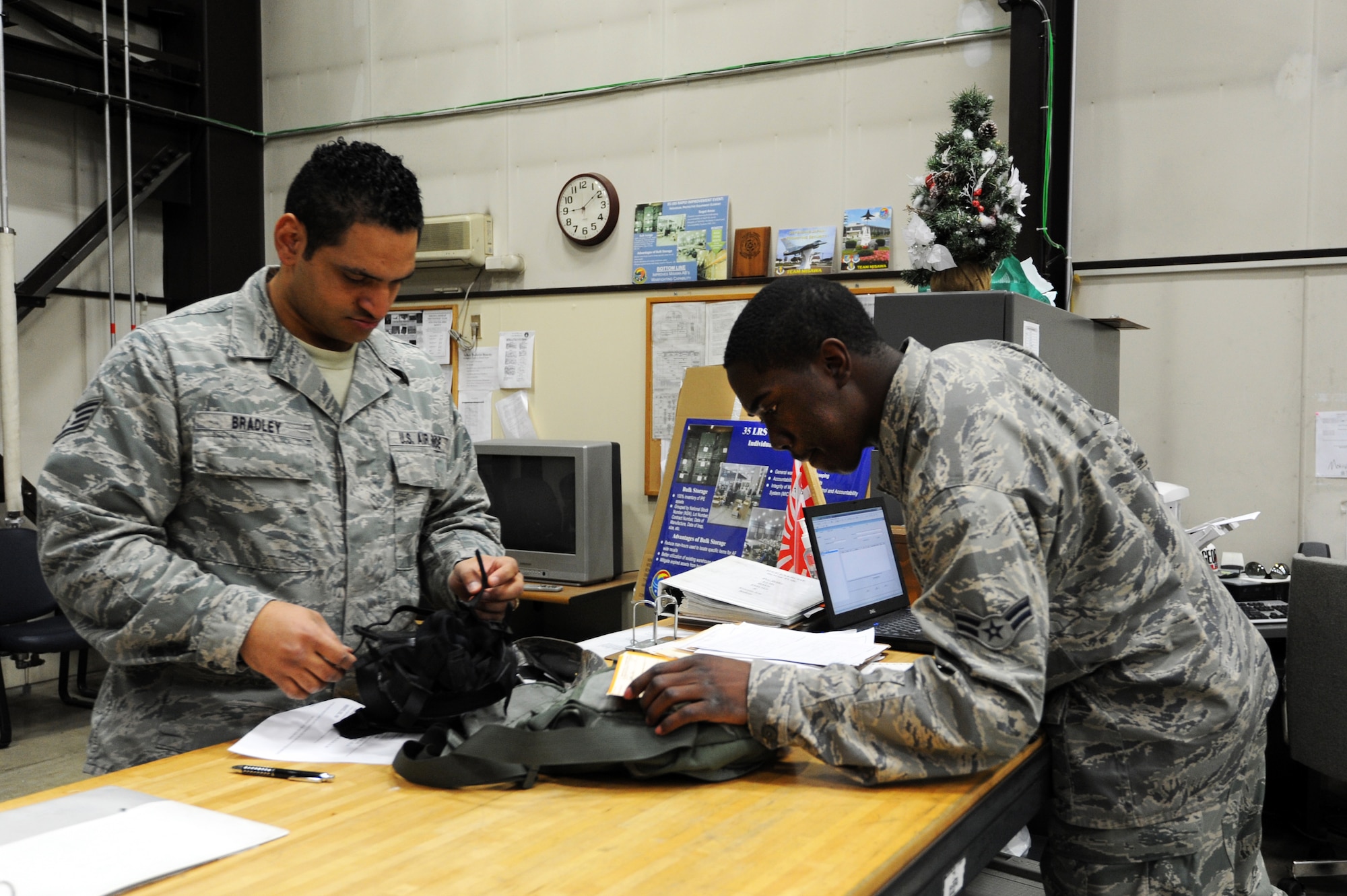 MISAWA AIR BASE, Japan -- Airman 1st Class Kevin Jackson, right, 35th Logistics Readiness Squadron individual protective equipment weapons journeyman, issues a gas mask to Staff Sgt. Aaron Bradley, 35th Communications Squadron postal clerk, in the IPE warehouse here, Feb. 9. LRS Airmen working in the IPE warehouse issue Mission Oriented Protective Posture gear, cold weather gear, deployment gear and weapons to servicemembers on base. (U.S. Air Force Photo/Airman 1st Class Kia Atkins)
