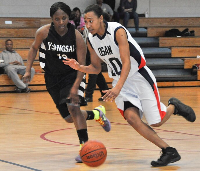 Ashonda Williams brings the ball upcourt against Yongsan's Erica Washington late in a 69-62 overtime win Feb. 12, 2012.  Williams -- who is assigned to the 51st Operations Support Squadron -- played point guard, shot outside and defended in the paint to spur the Osan women's varsity basketball team.  (Air Force photo/Senior Master Sgt. Stuart Camp)