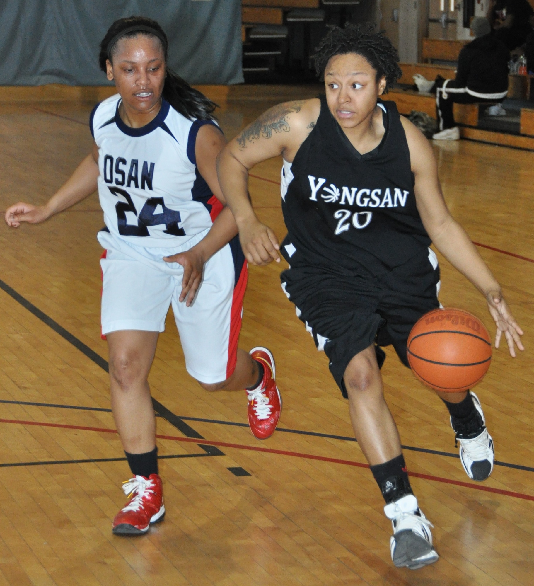 Osan's Serina Foy trails Yongsan's Karlisha Thompson during the first half of their Feb. 12, 2012, game in the Osan Air Base Fitness Center.  Osan outlasted their opponent 69-62 in overtime. Foy is assigned to the 51st Security Forces Squadron.  (Air Force photo/Senior Master Sgt. Stuart Camp)