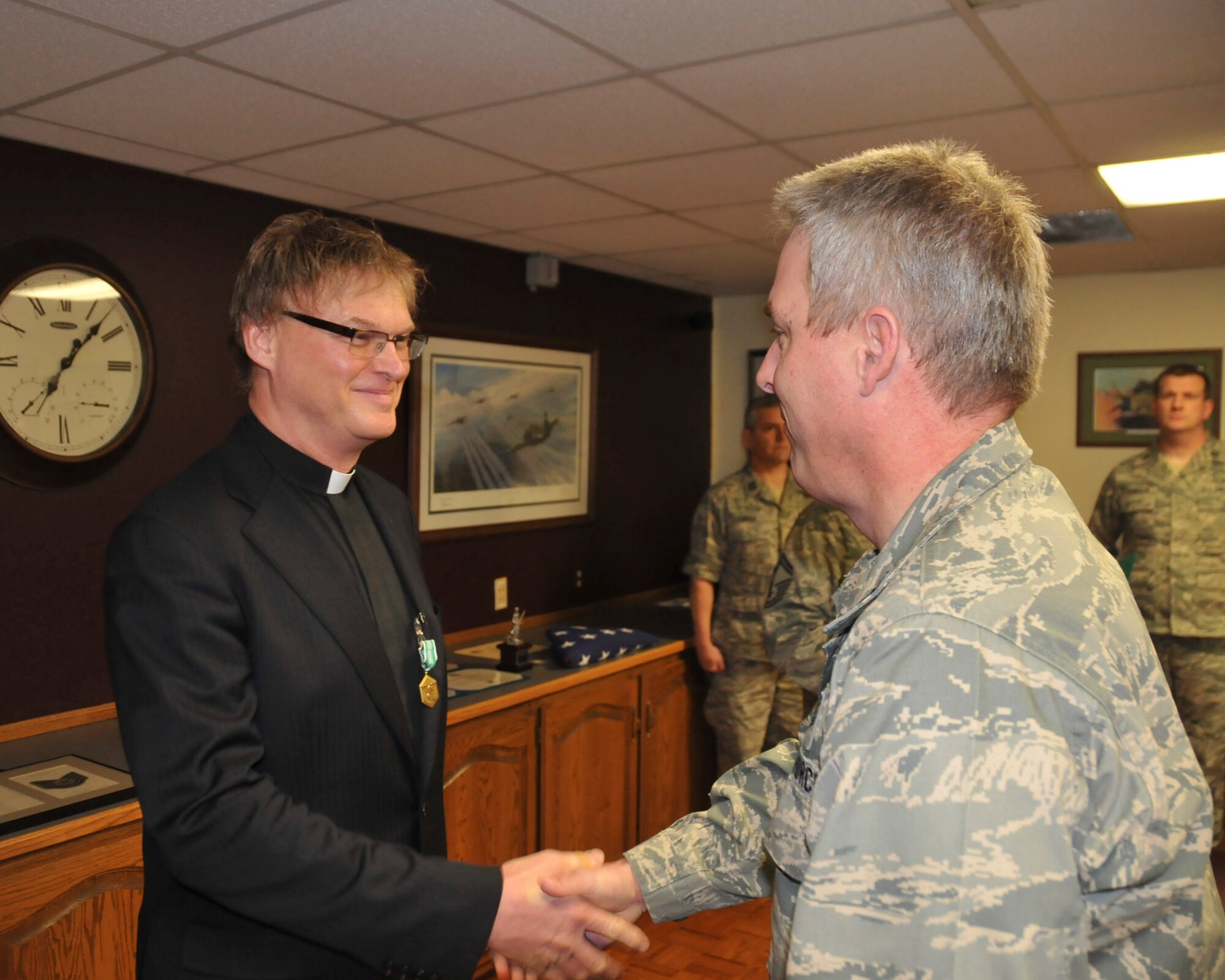Col. Michael Mayo of the 128th Air Refueling Wing congratulates Chaplain Christopher Myers after presenting him with the Army Accommodation Medal. Chaplain Myers earned the Accommodation Medal while stationed at Landstuhl Regional Medical Center in Germany.