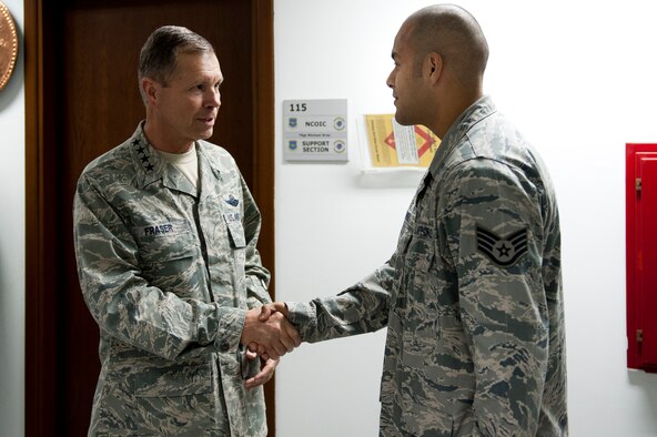 Gen. William M. Fraser III, U.S. Transportation Command commander, left, speaks with Staff Sgt. Juan Munoz, 728th Air Mobility Squadron, about his recent contributions to the squadron Feb. 9, 2012, at Incirlik Air Base, Turkey. Fraser received a briefing from wing leadership, toured several base facilities and visited with Airmen to thank them for their hard work. (U.S. Air Force photo/Tech. Sgt. Michael B. Keller)(Released)