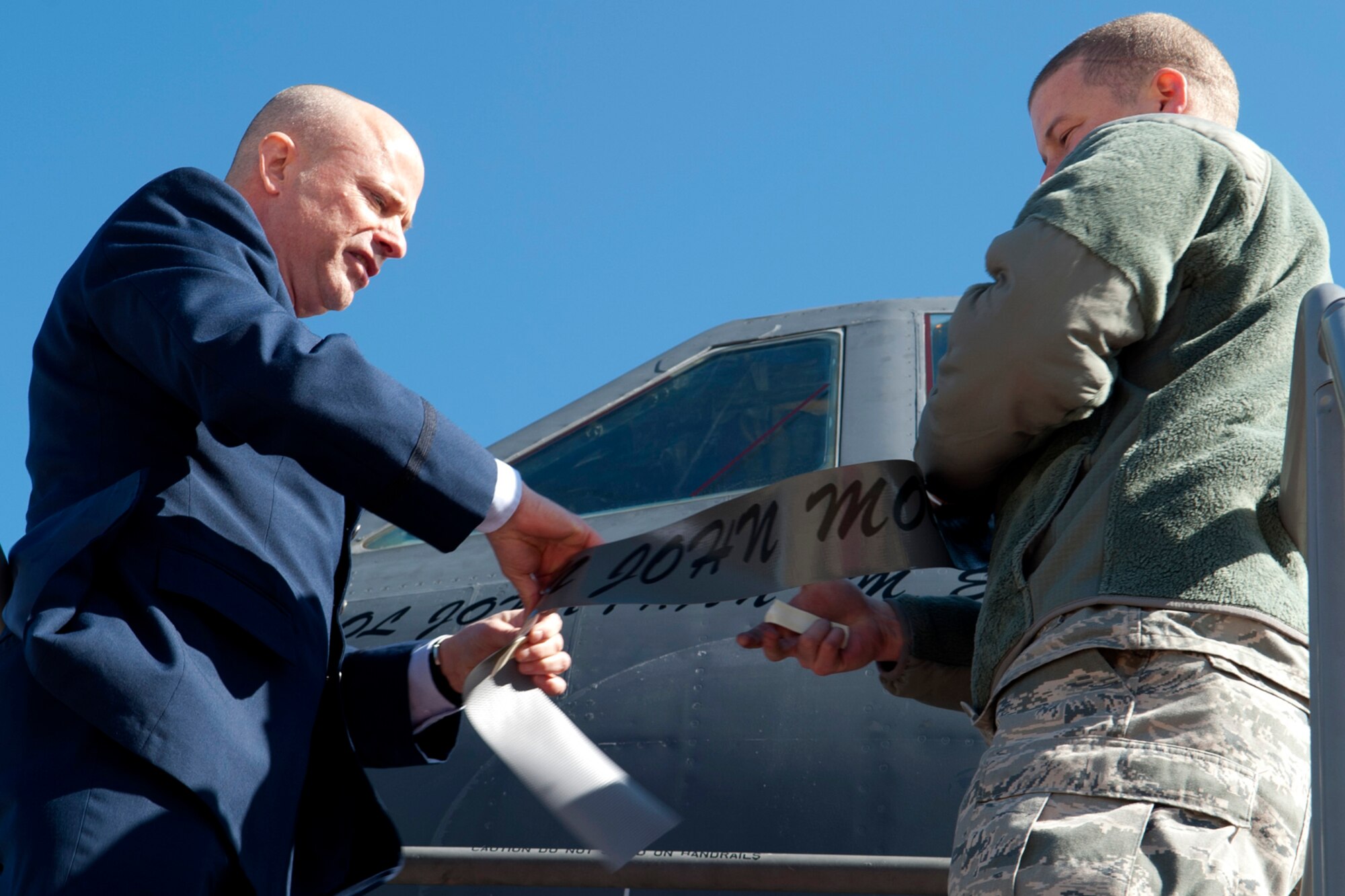 U.S. Air Force Col. Jonathan Ellis, 307th Bomb Wing commander, helps U.S. Air Force Tech. Sgt. Thomas Gooch, 2nd Aircraft Maintenance Squadron crew chief, remove the name of the former 307th Bomb Wing commander from a B-52H Stratofortress, Barksdale Air Force Base, La., Feb. 11, 2012. Ellis, the former commander of the 940th Operations Group, Beale Air Force Base, Calif., assumed command of the 307th during a ceremony at Barksdale. (U.S. Air Force photo by Master Sgt. Greg Steele/Released)