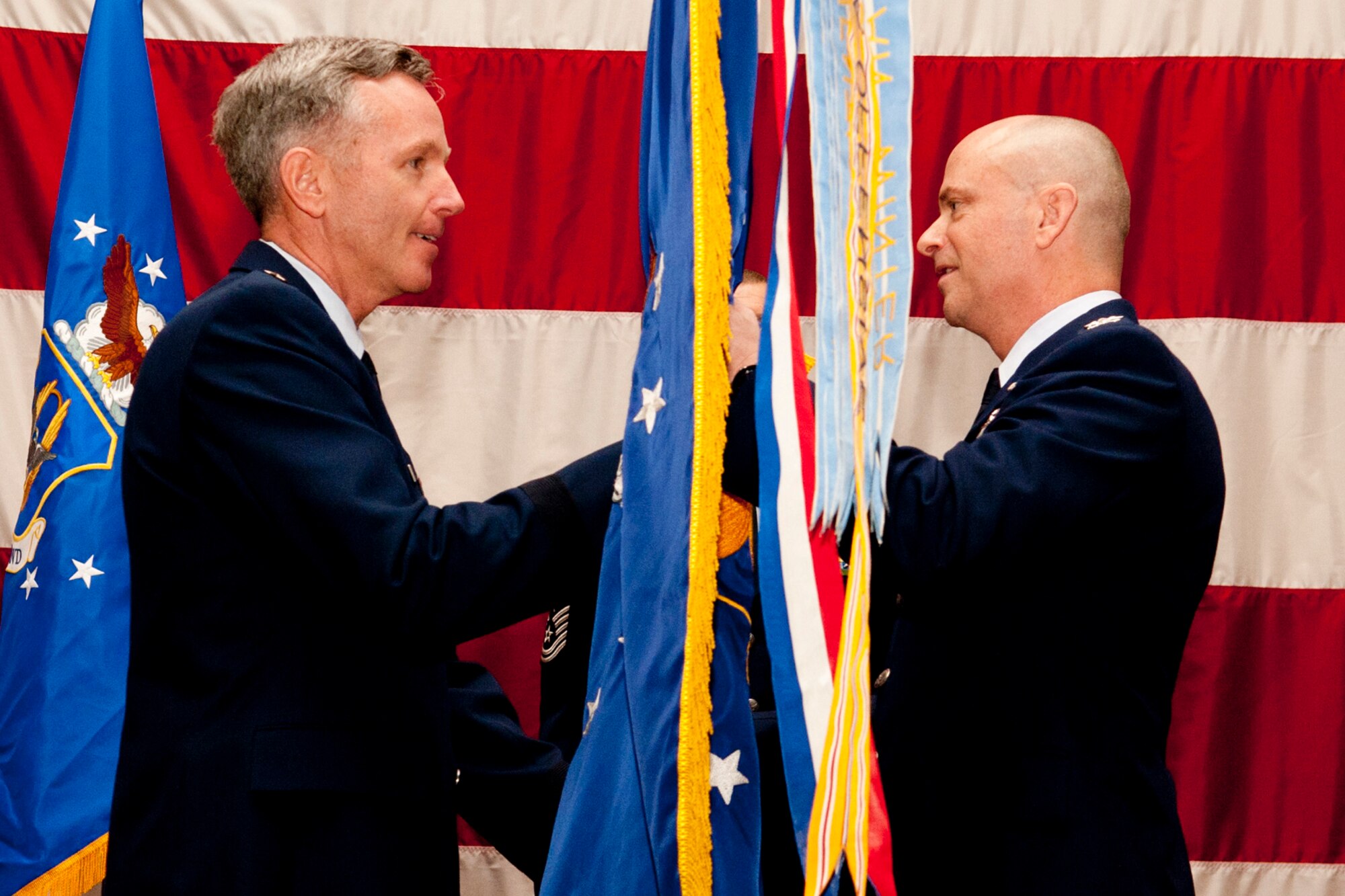 U.S. Air Force Brig. Gen. William Binger, 10th Air Force commander, hands the 307th Bomb Wing flag to Col. Jonathan Ellis during a Change of Command ceremony, Barksdale Air Force Base, La., Feb. 11, 2012. Ellis, the former commander of the 940th Operations Group, Beale Air Force Base, Calif., assumed command of the 307th. (U.S. Air Force photo by Master Sgt. Greg Steele/Released)