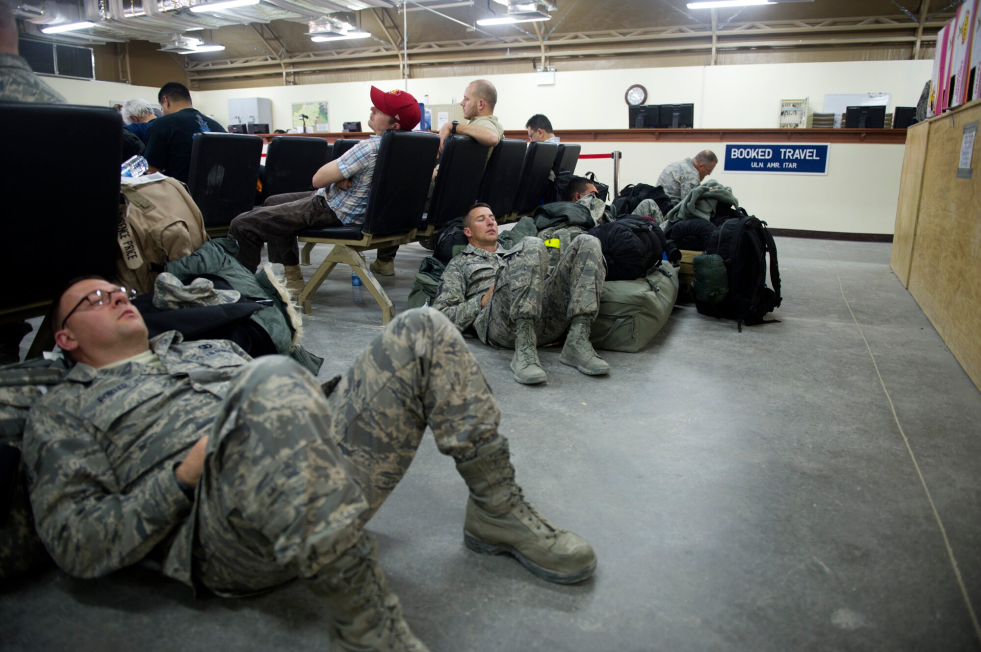 Members of the U.S. Air Forces Central Band Afterburner sleep in a passenger terminal at an undisclosed location in Southwest Asia, Jan. 29, 2012. This was the band's second stop of the day as the traveled to the Transit Center at Manas in Kyrgyzstan. (U.S. Air Force photo by Staff Sgt. David Salanitri/Released)